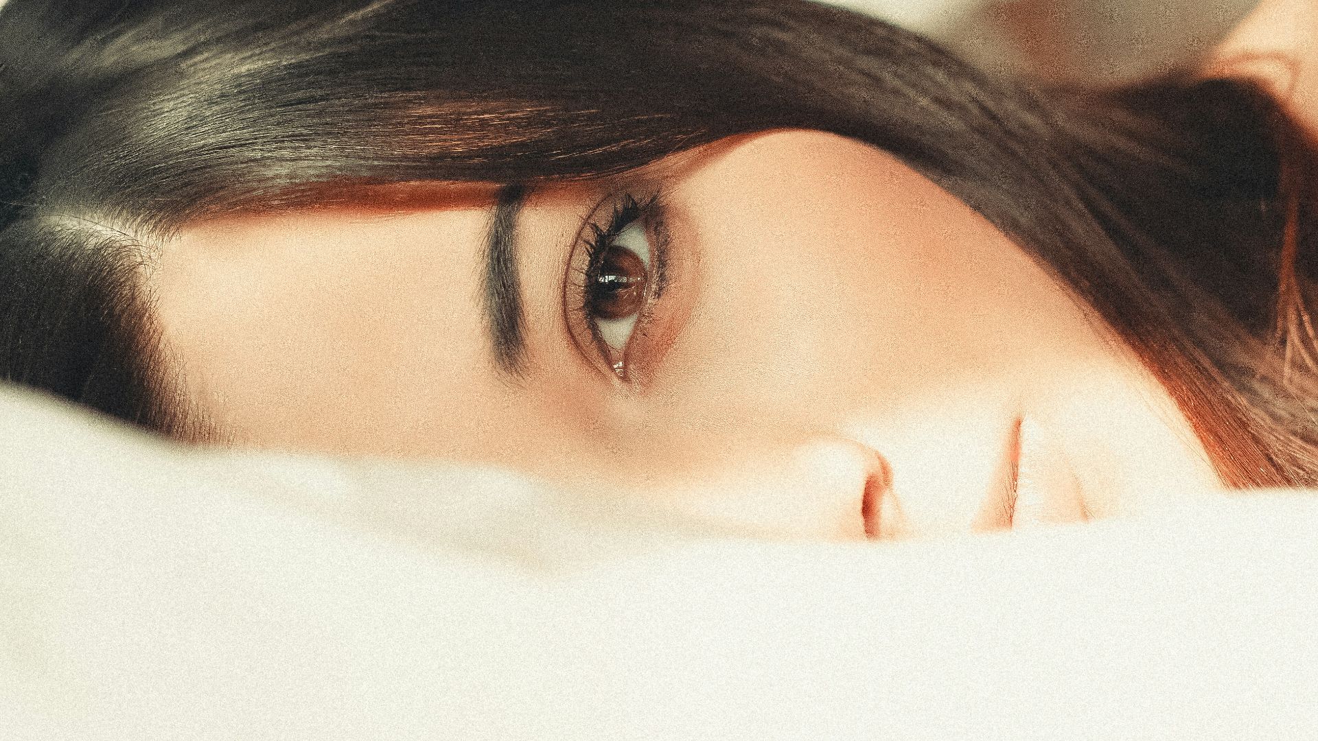 woman covering her face with white textile