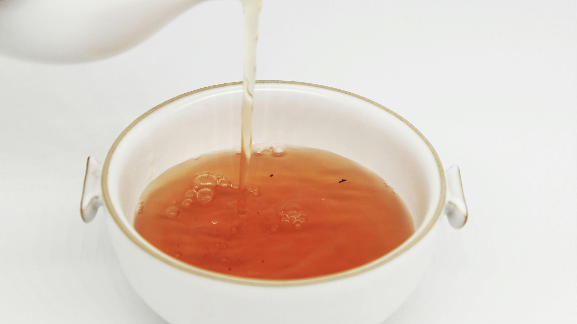 tea pours into white teacup