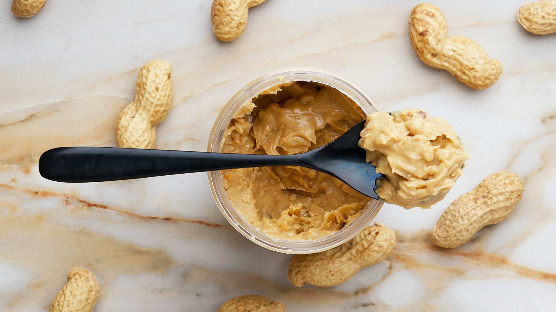 peanut butter with black spoon