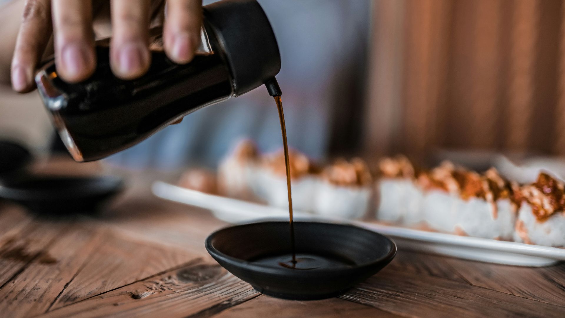 person pouring coffee on black ceramic mug