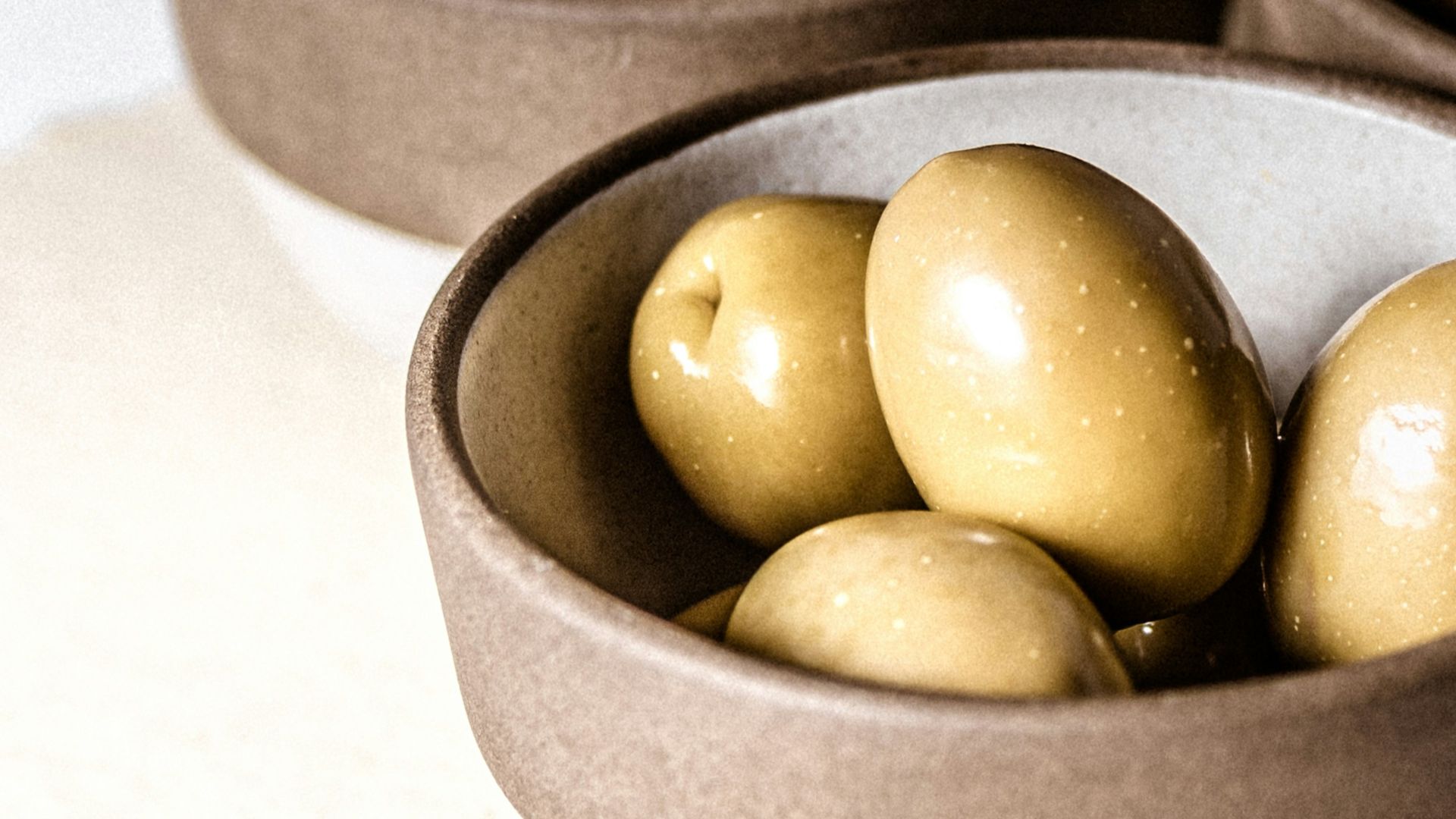 green round fruits on black ceramic bowl