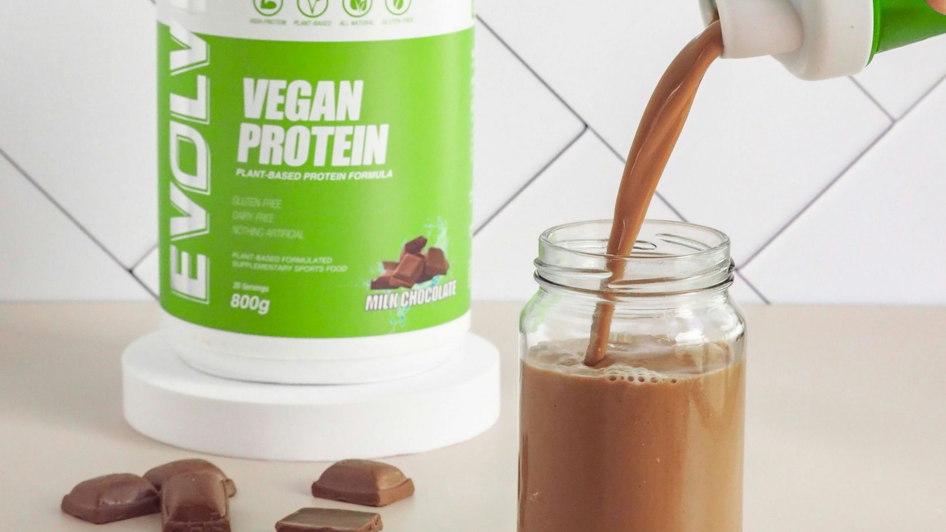 a person pouring a drink into a mason jar