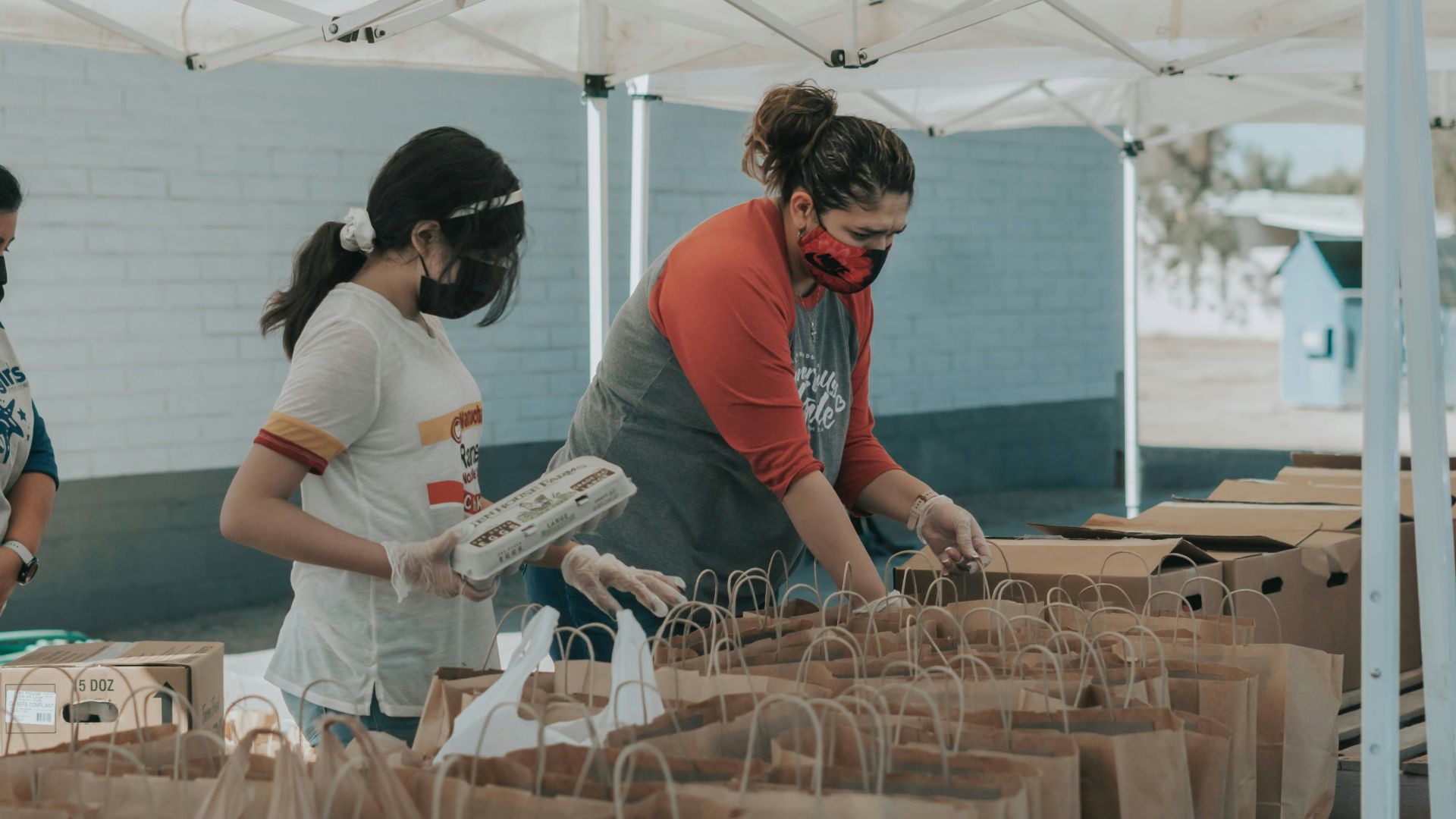man in red t-shirt holding white plastic bottle
