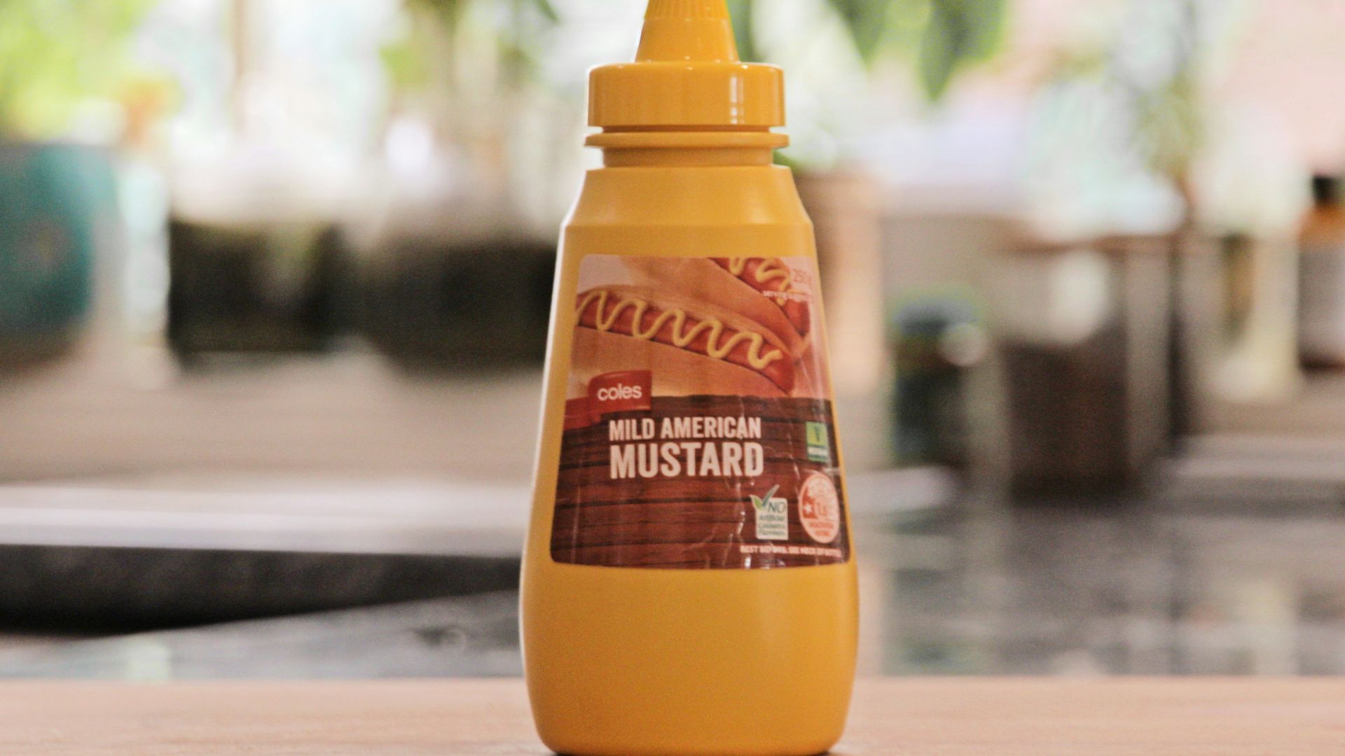 a bottle of mustard sitting on top of a wooden table