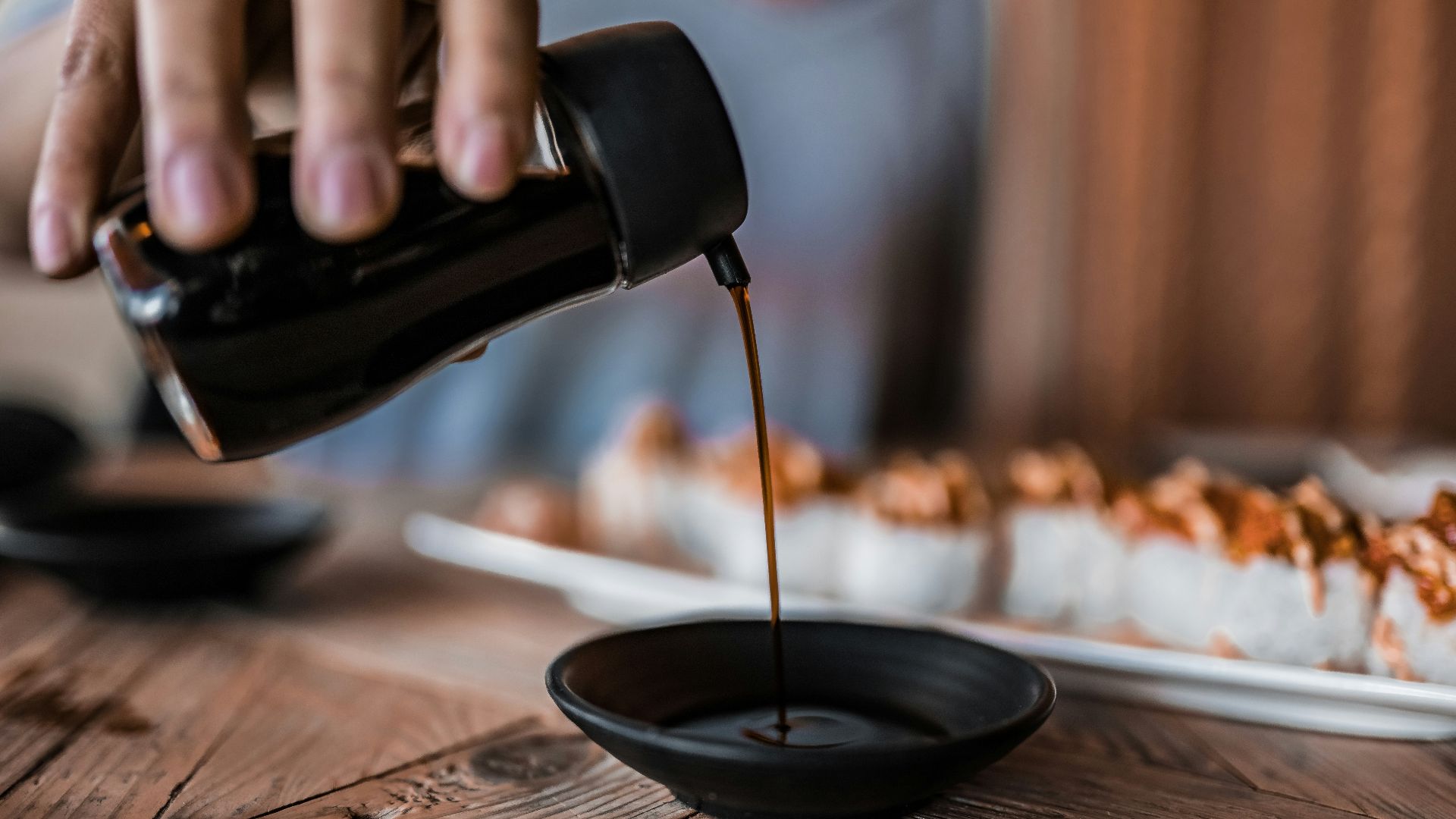person pouring coffee on black ceramic mug