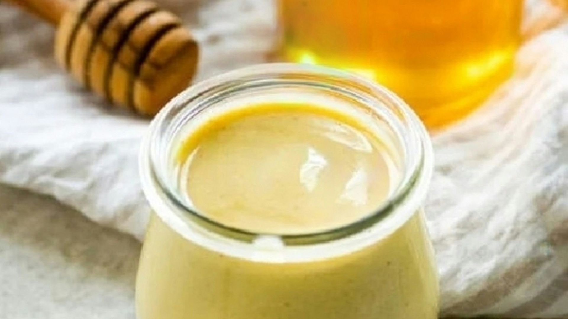 a jar of honey sits next to a jar of honey