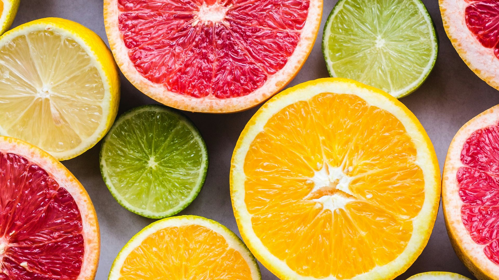 flat lay photography of sliced pomegranate, lime, and lemon