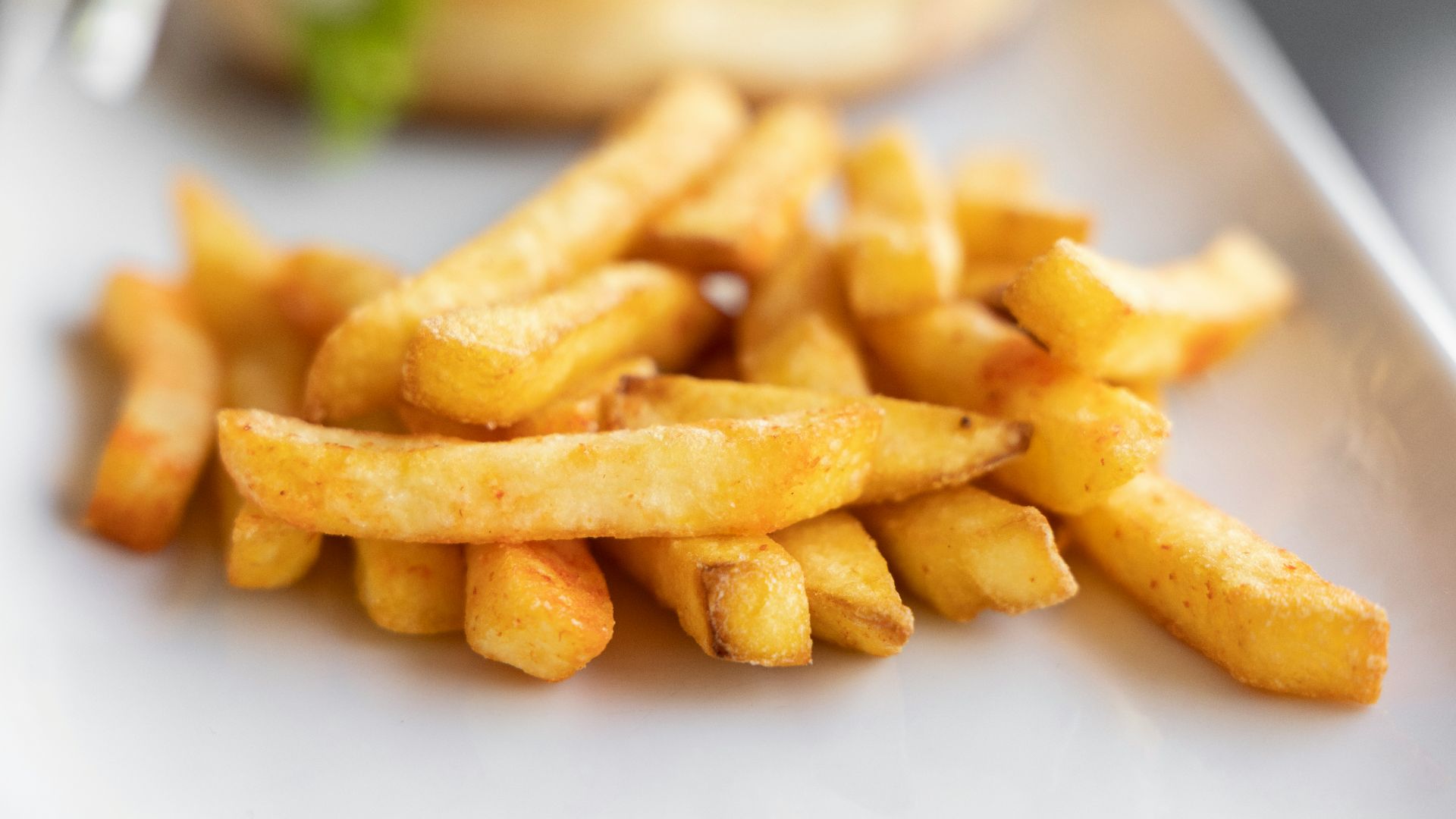 a white plate topped with french fries next to a sandwich