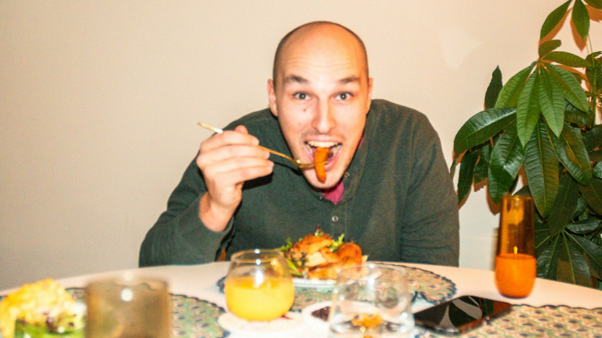 a man sitting at a table with a plate of food in front of him