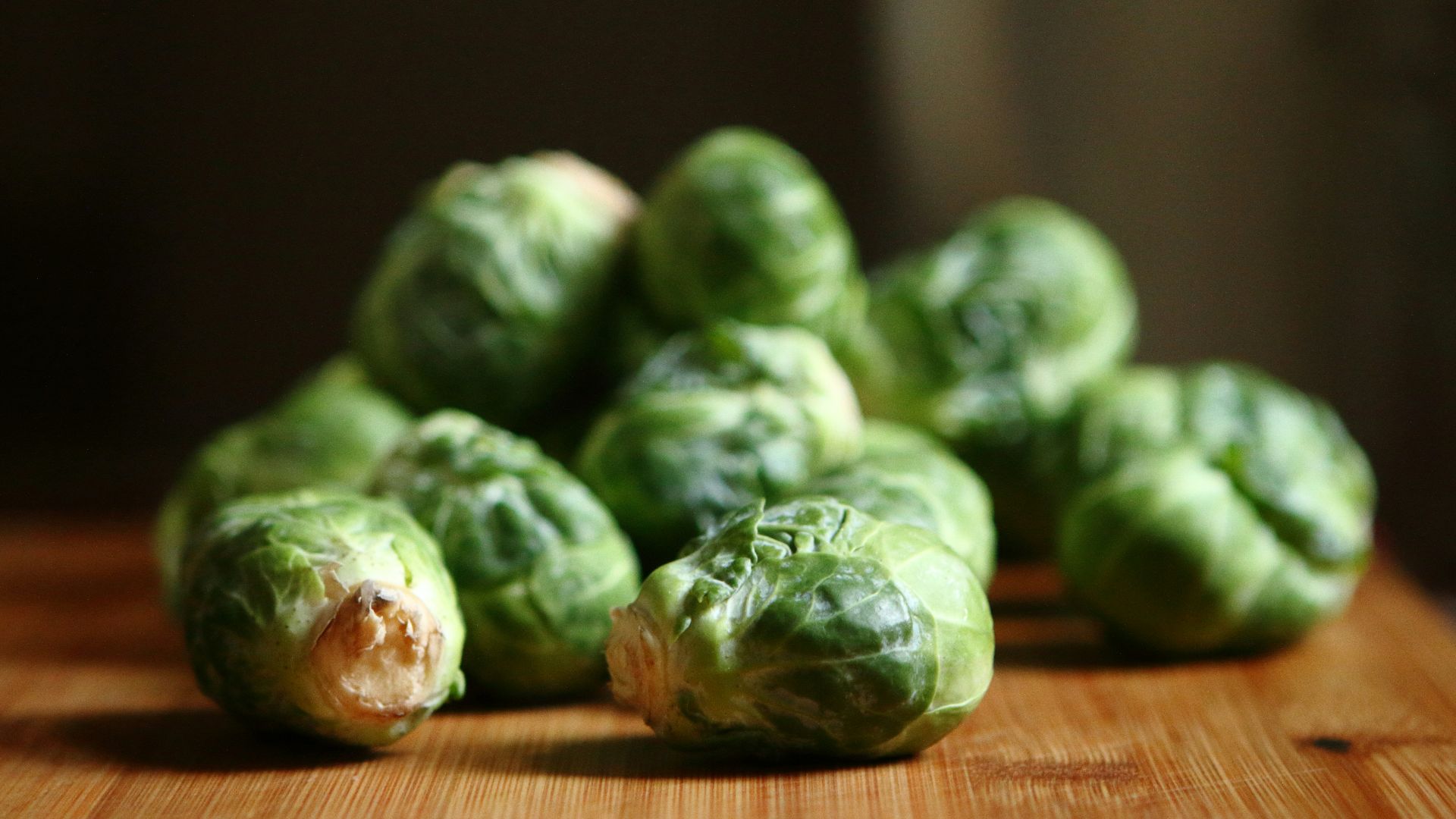 shallow depth of fields photography of green vegetable on brown wooden panel