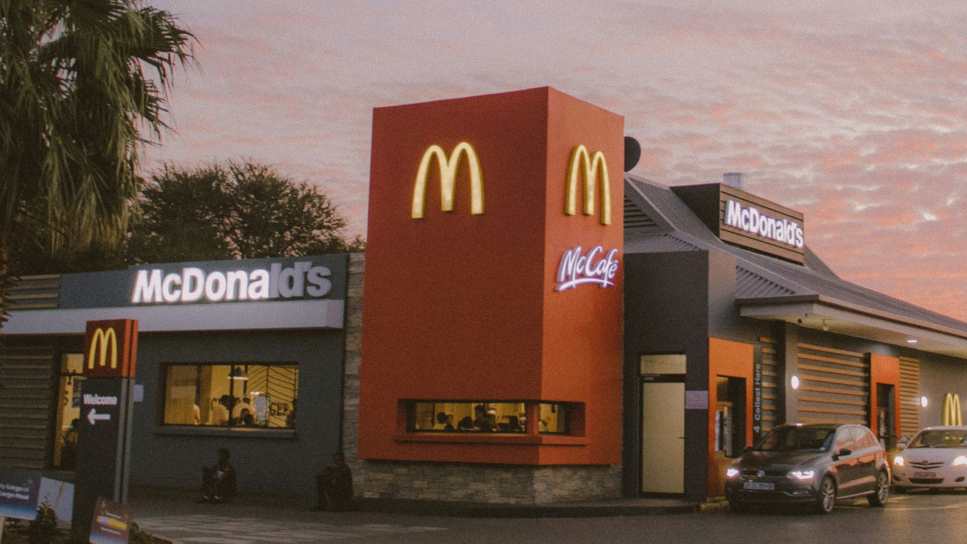 red and white concrete building near palm trees during daytime