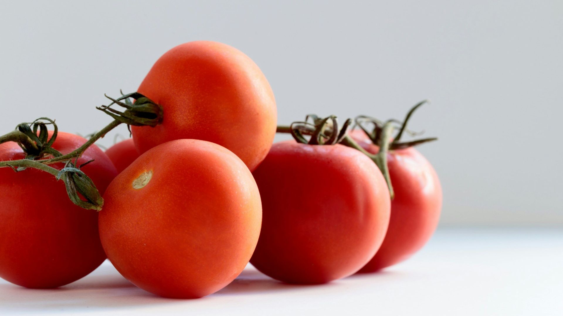 red tomato on white surface