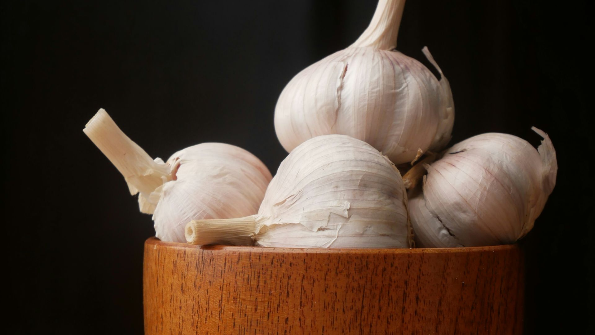 garlic on brown wooden bowl