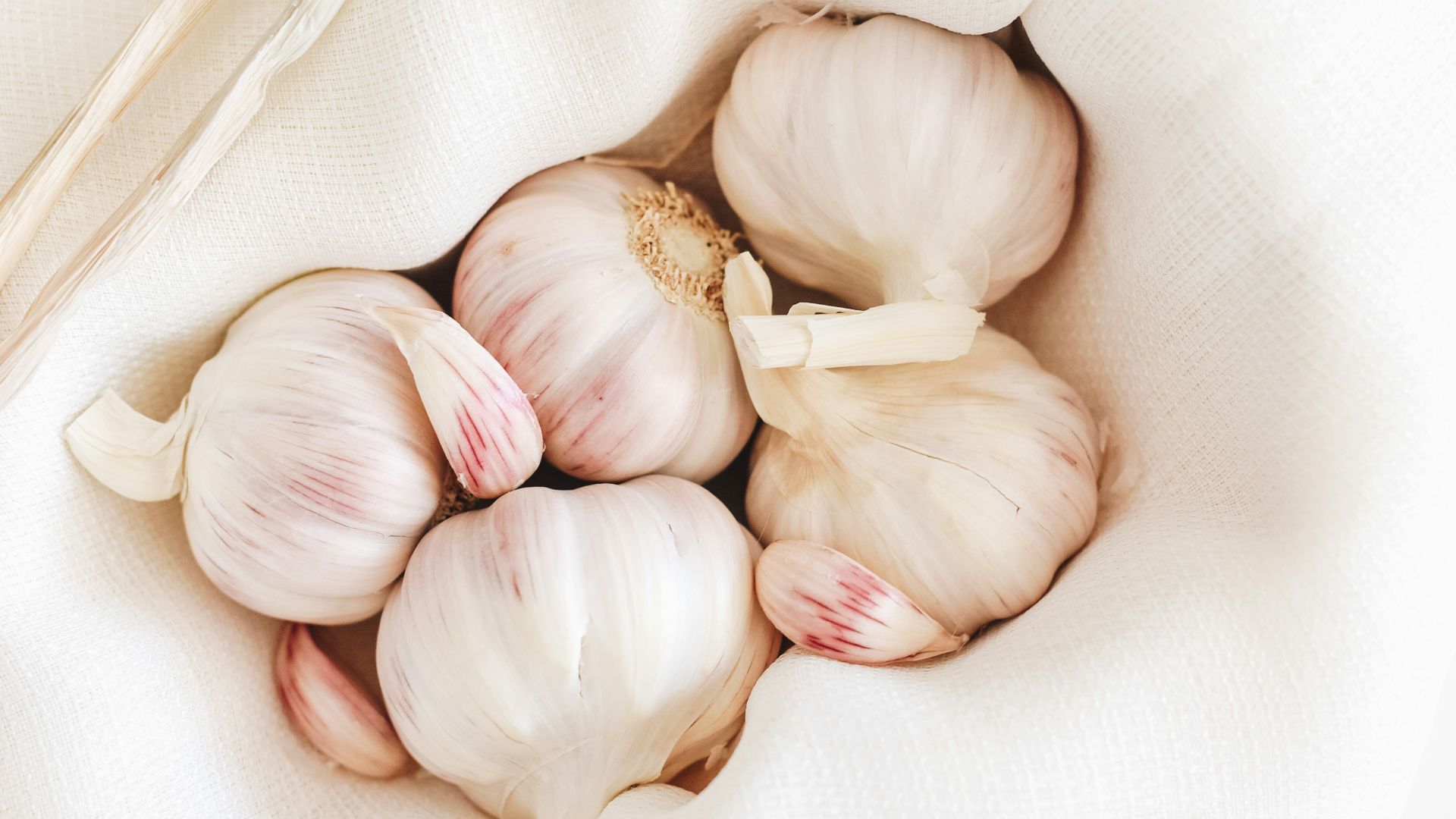five garlic on white textile