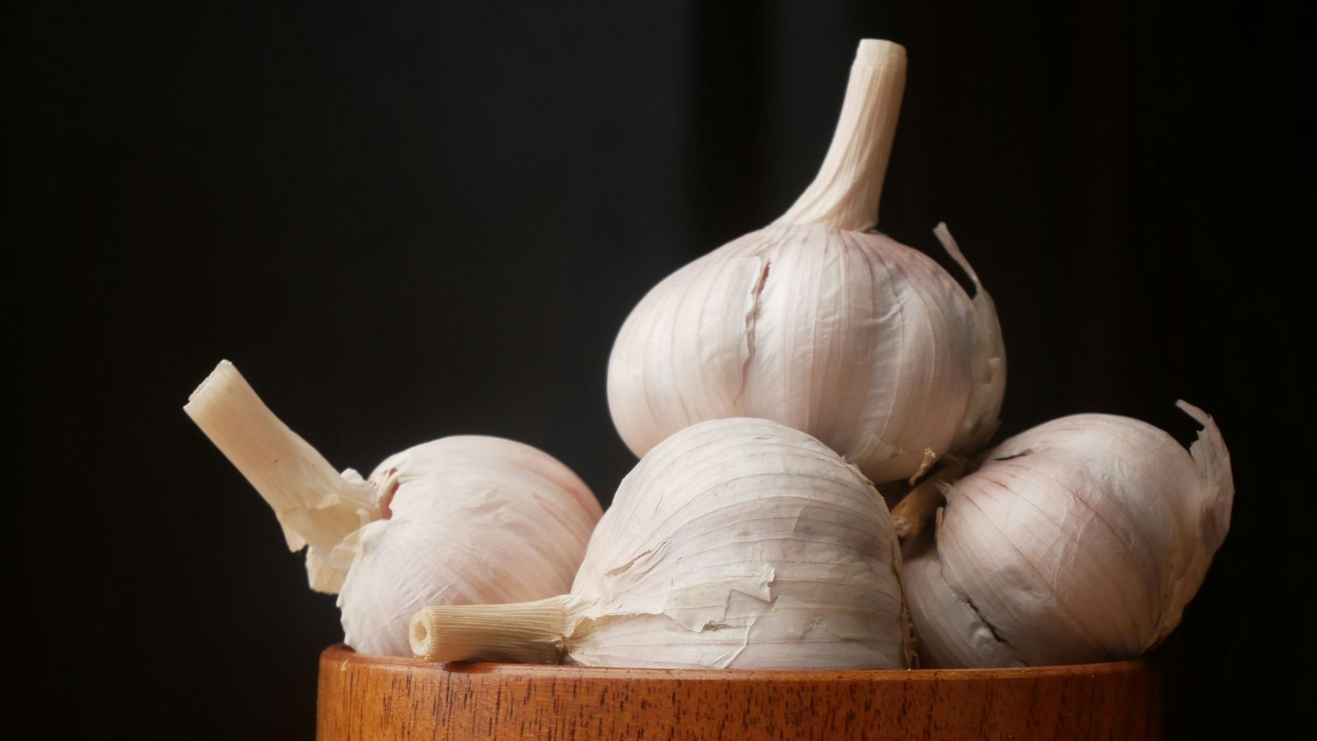 garlic on brown wooden bowl