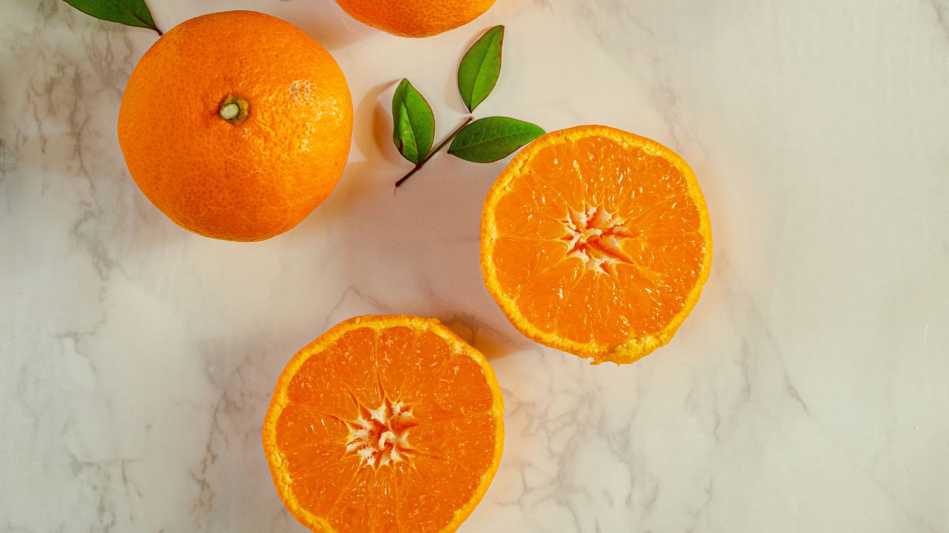sliced orange fruits on white surface
