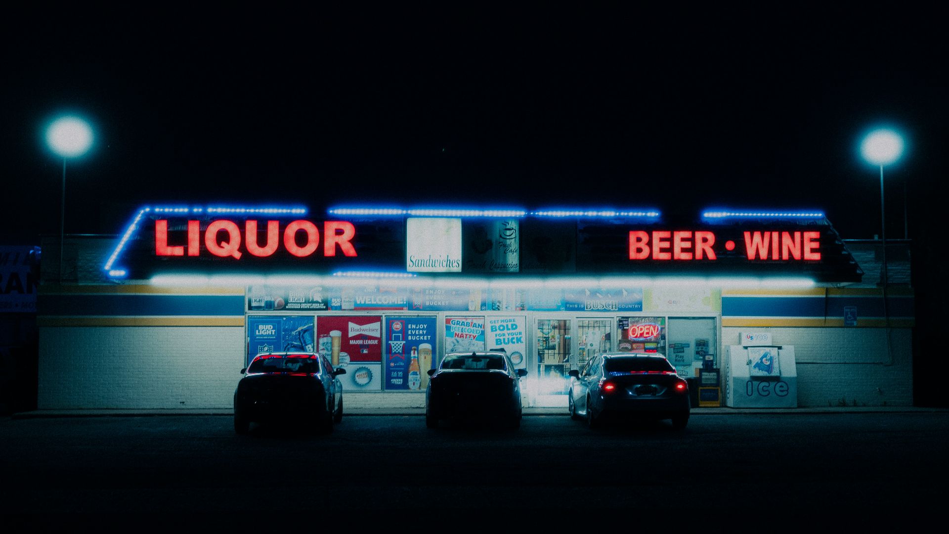 two cars parked in front of a liquor store