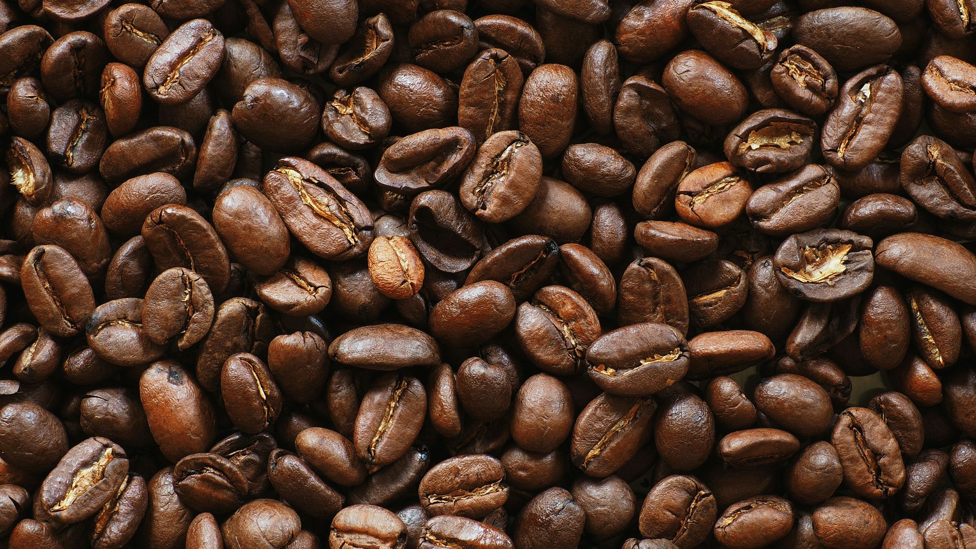 brown coffee beans on black surface