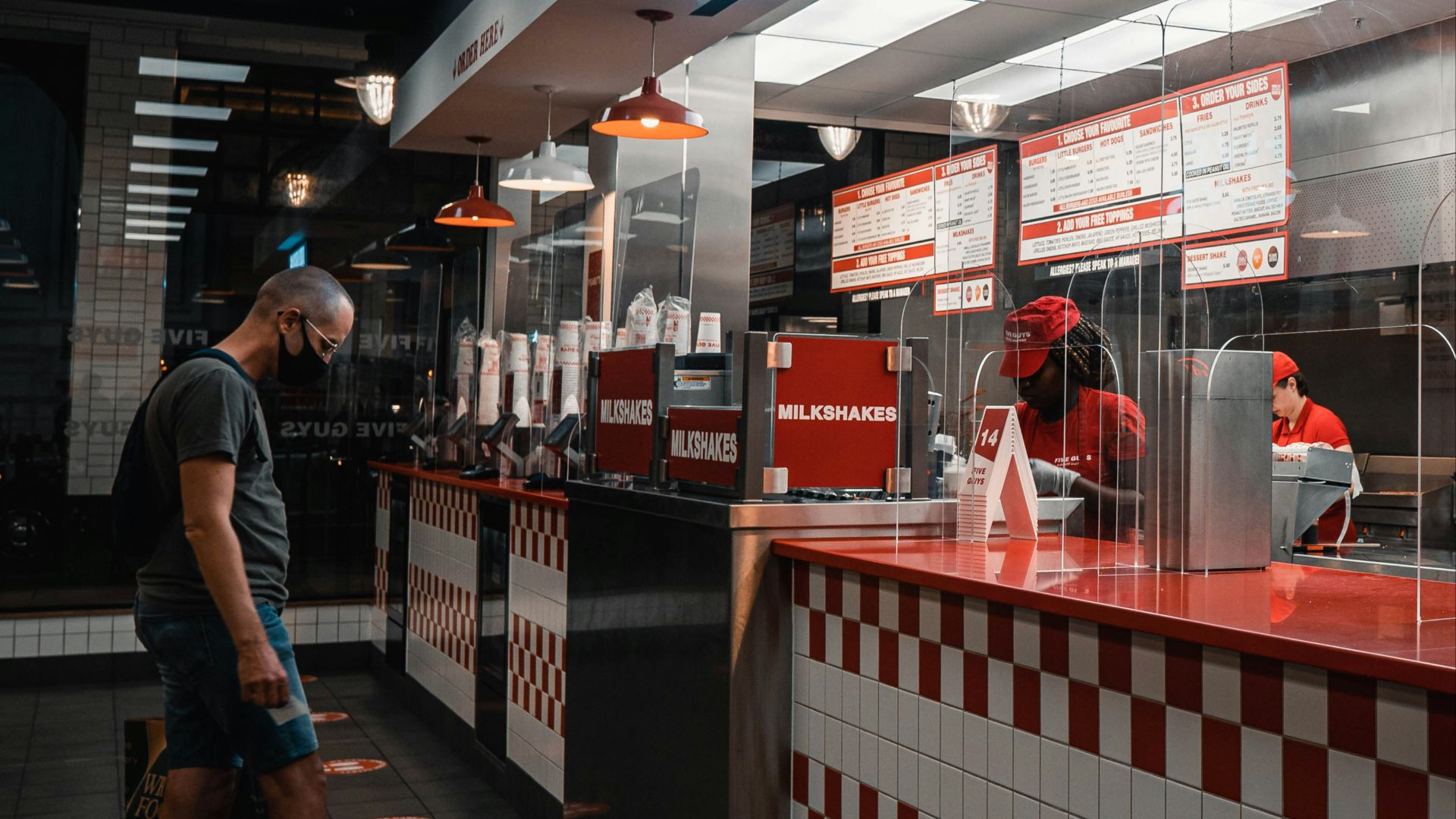 man in black t-shirt and blue denim jeans walking on the street