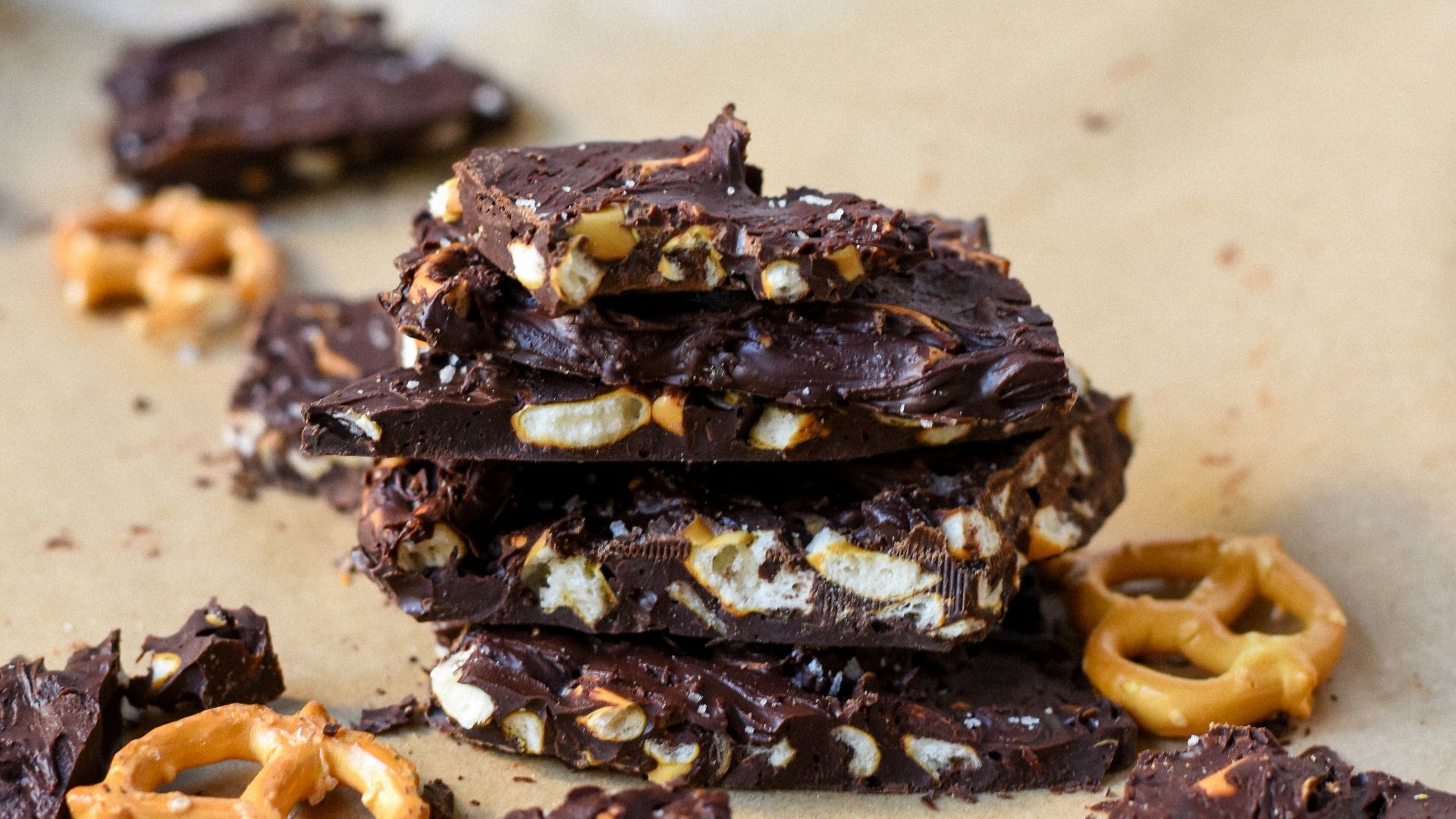 a pile of chocolate covered pretzels on top of a piece of parchment paper