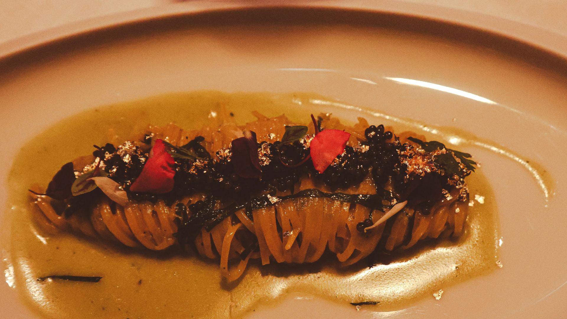 Pasta dish with sauce, herbs, and garnish.