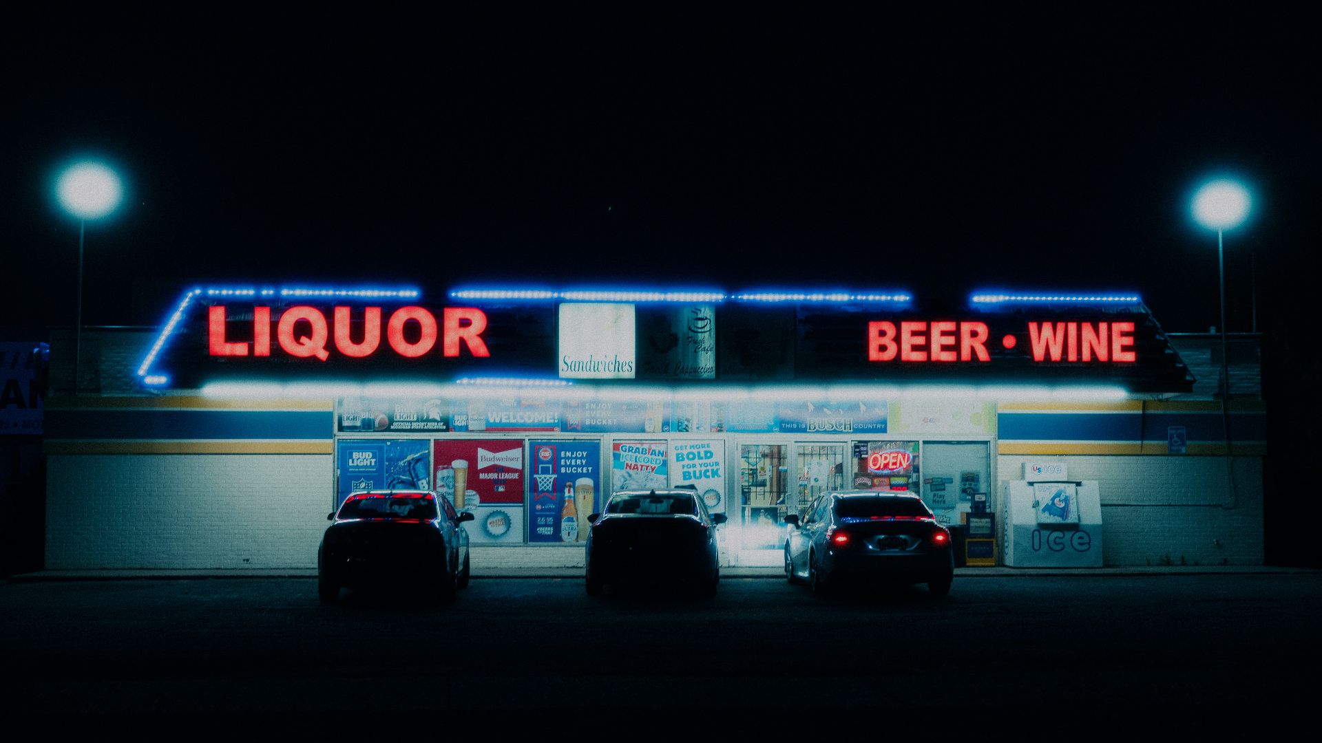 two cars parked in front of a liquor store