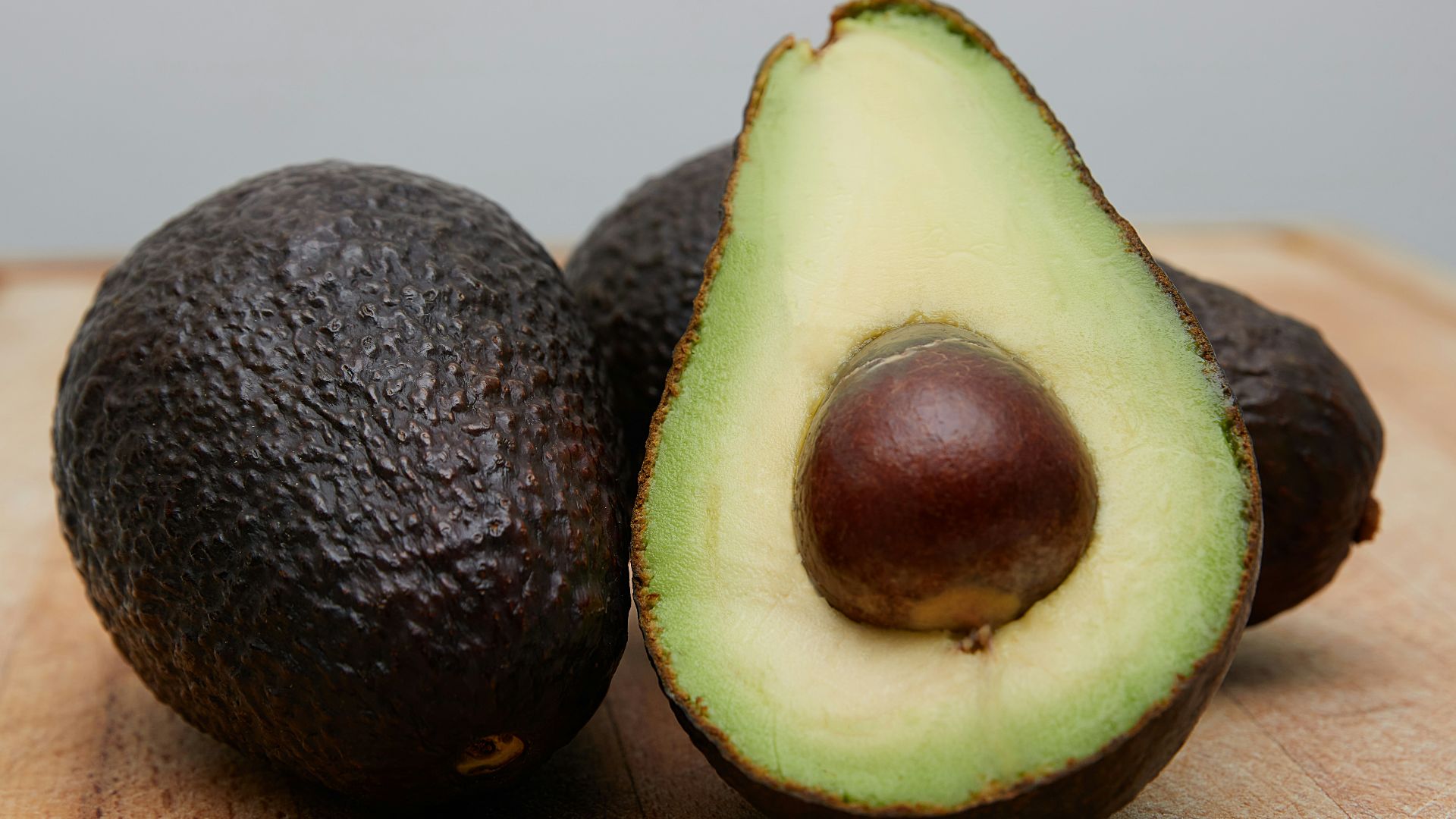 sliced avocado fruit on brown wooden table