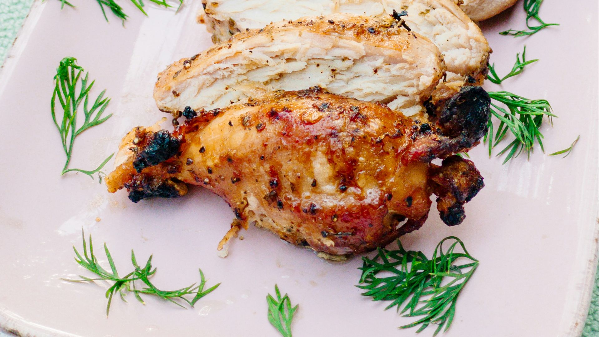 a pink plate topped with meat covered in sauce