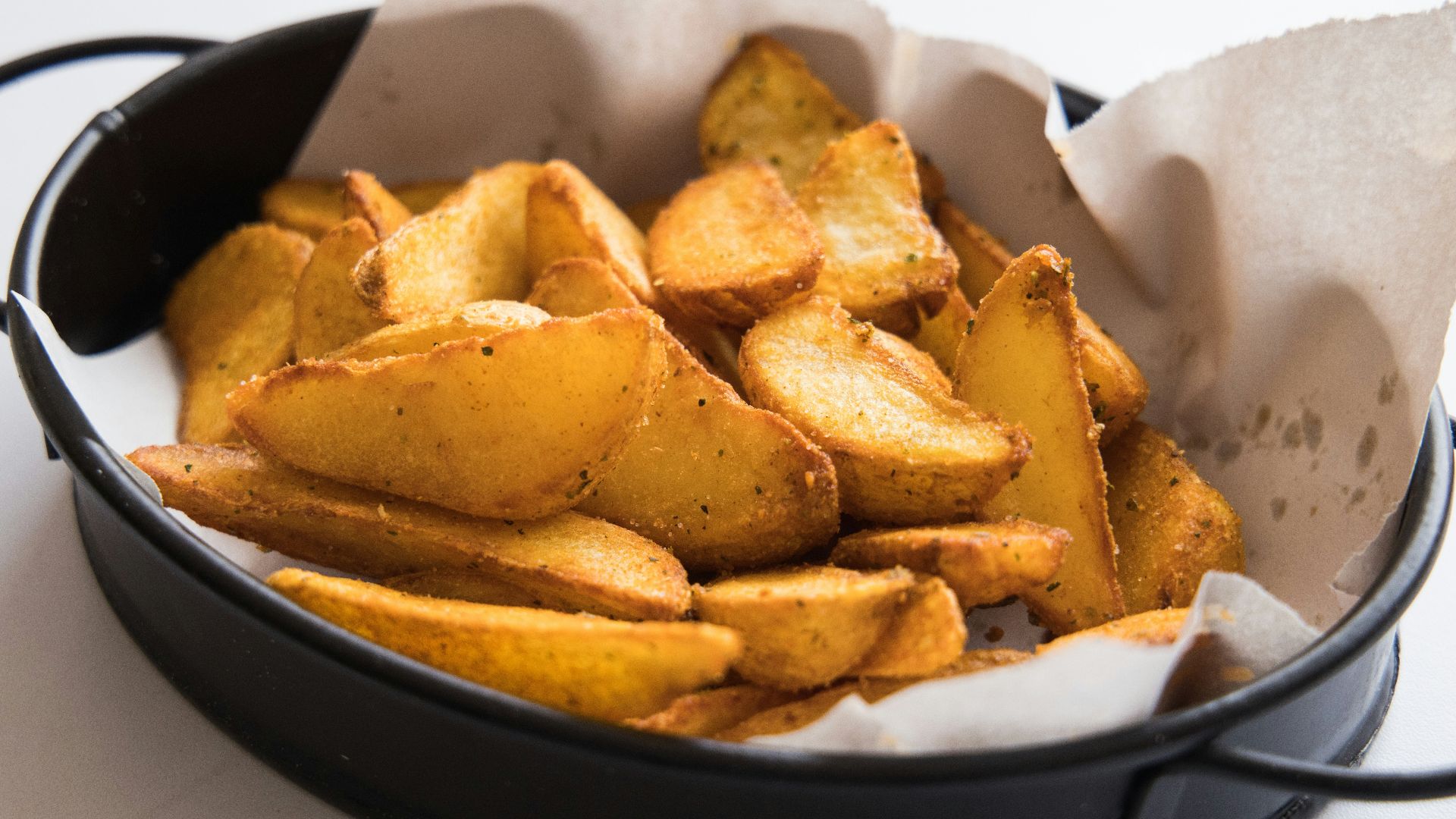 a black pan filled with potatoes on top of a table