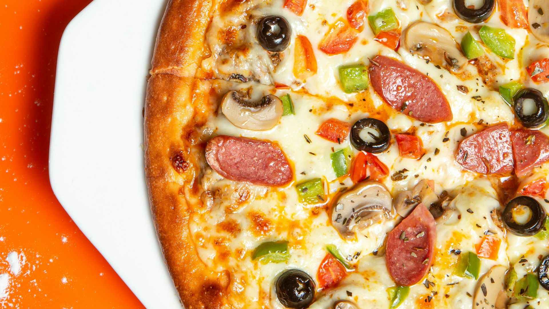 pizza with pepperoni and cheese on orange table