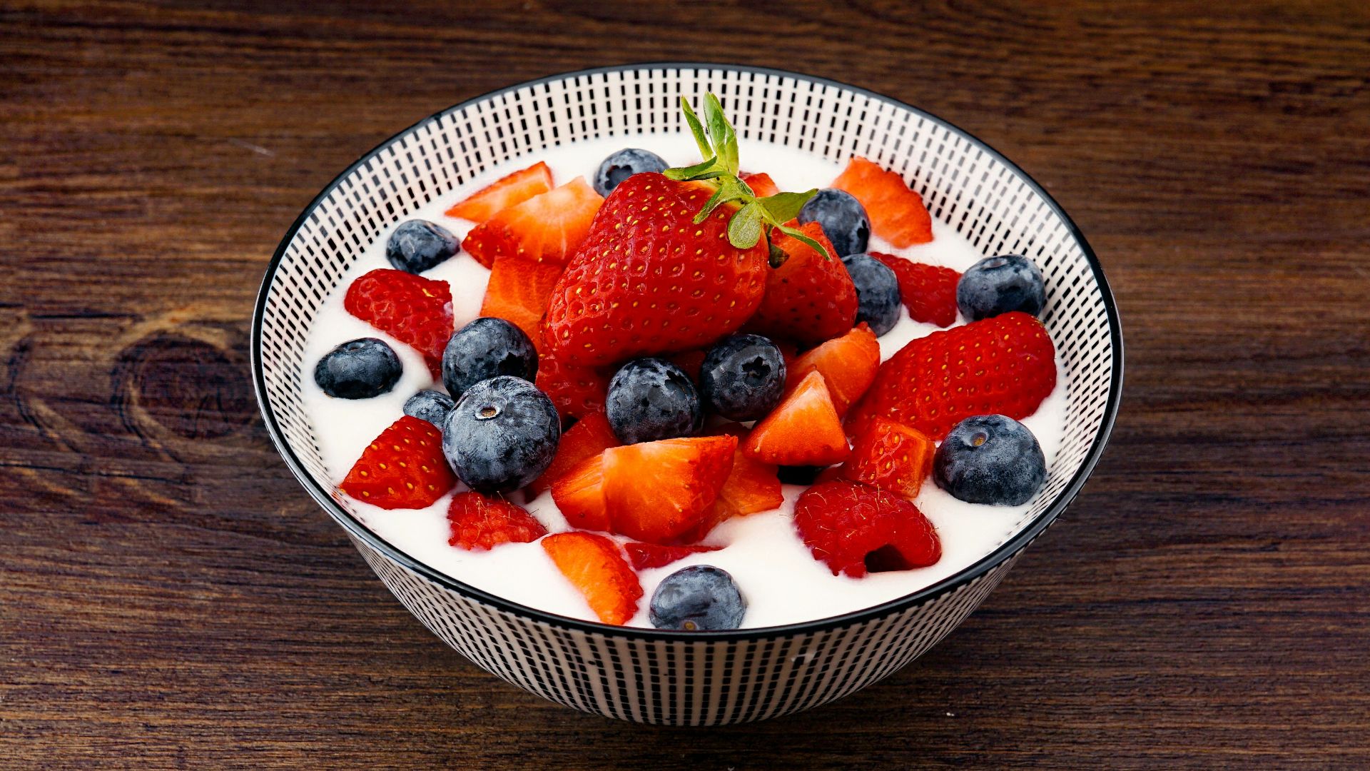 strawberry and blackberries on top of brown table
