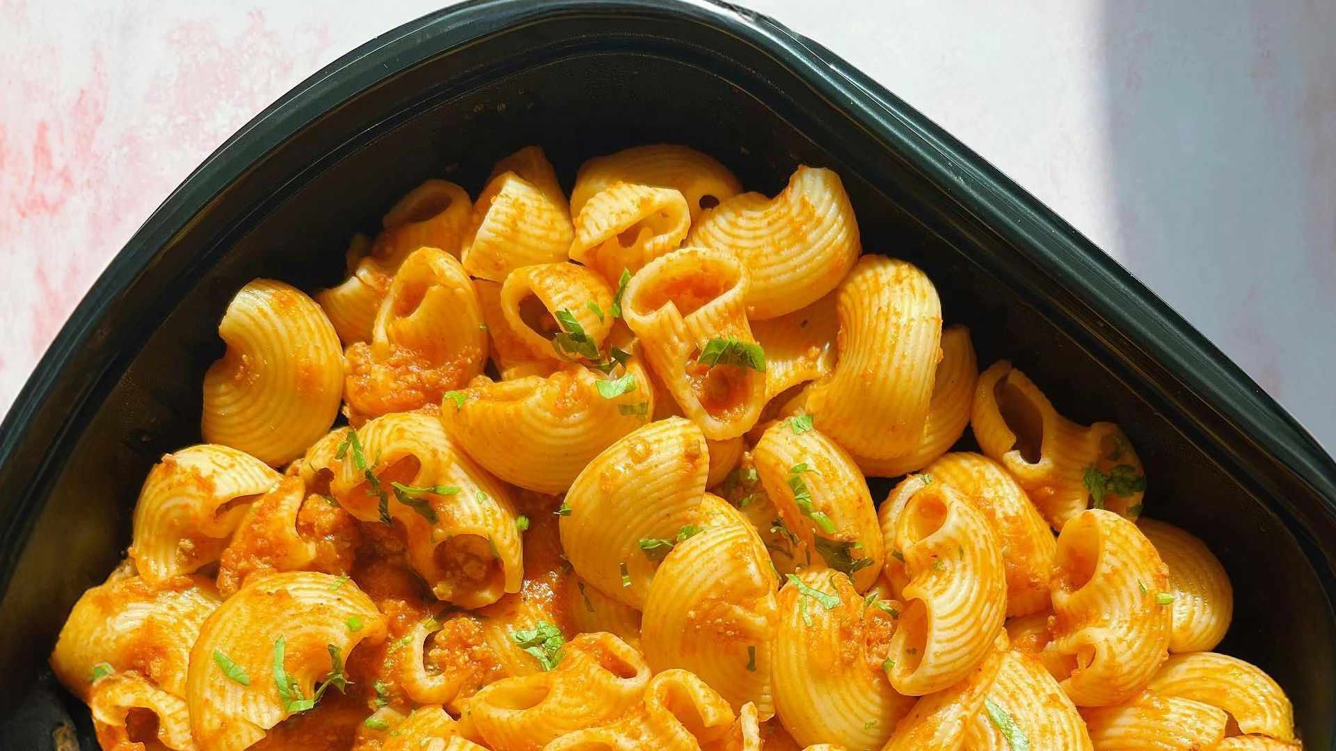 a black bowl filled with macaroni and cheese