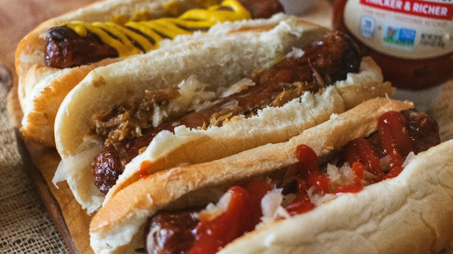 a couple of hot dogs sitting on top of a wooden cutting board