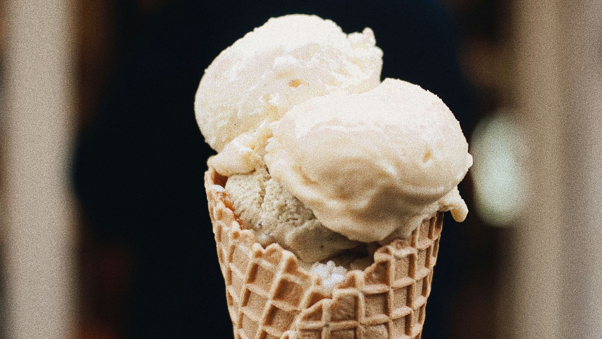 a hand holding a cone of ice cream