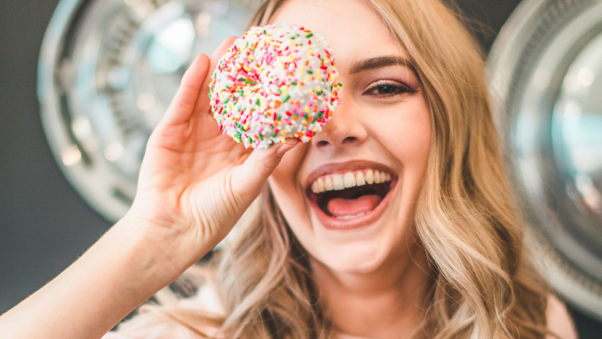 shallow focus photography of woman holding doughnut