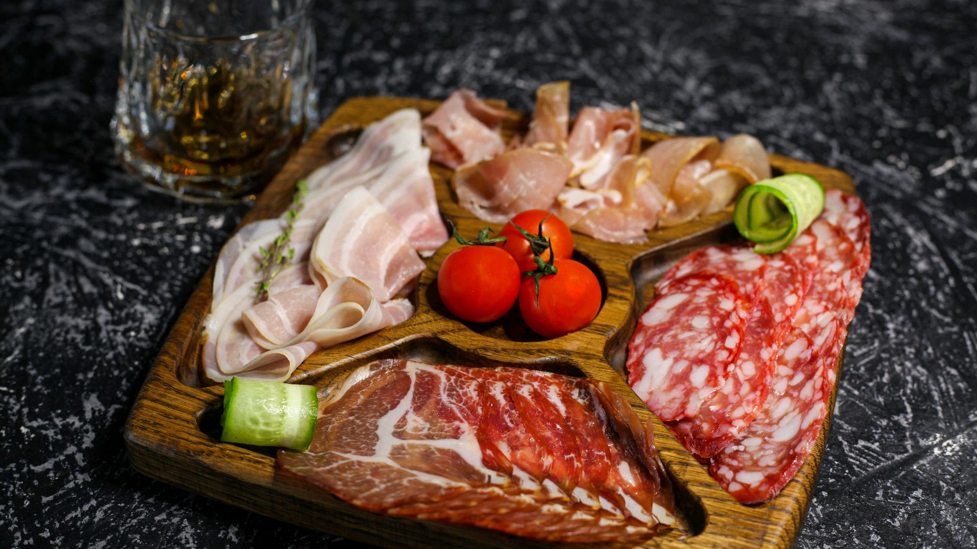 a wooden tray topped with meat and veggies