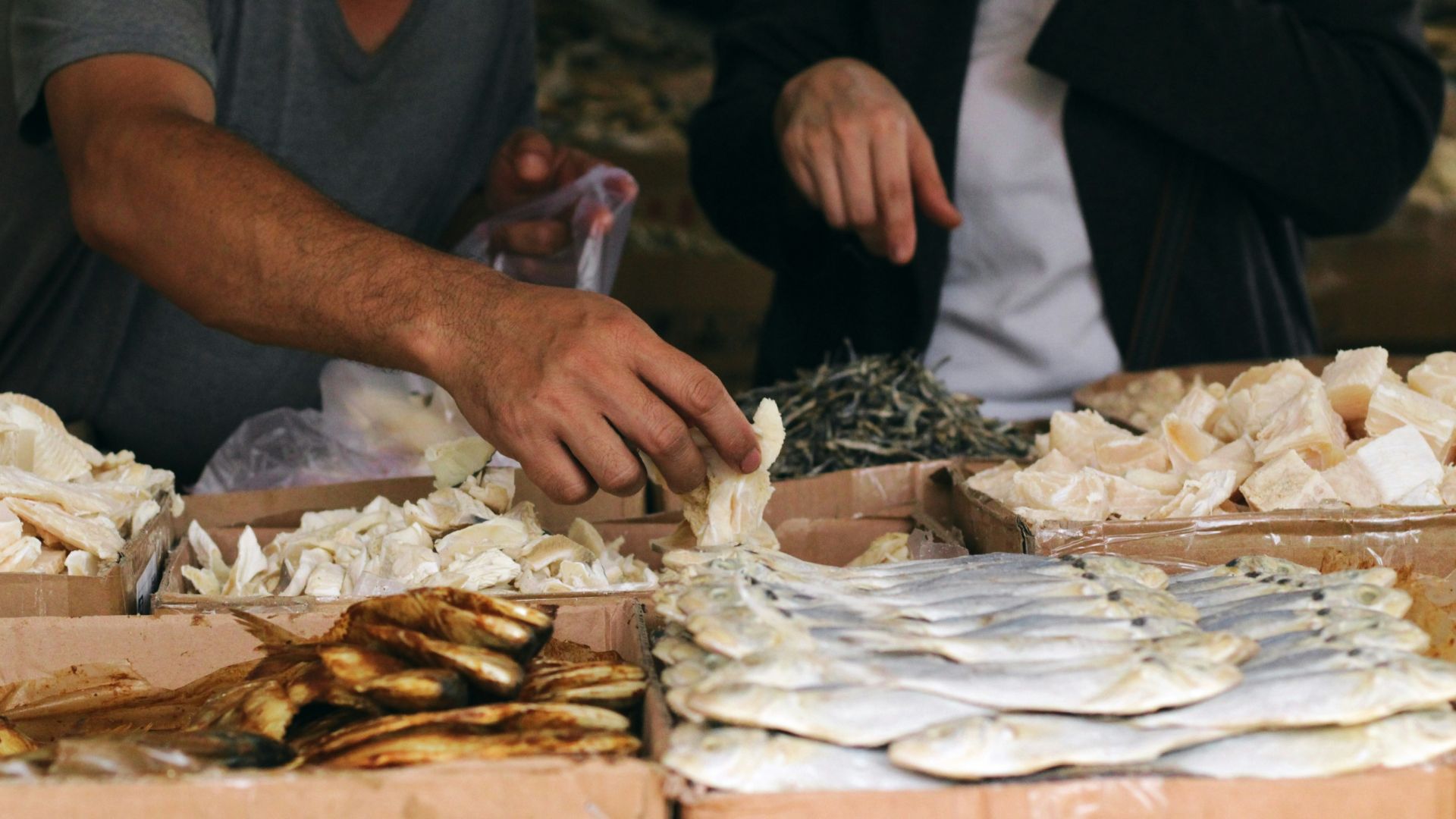 a man standing over a table filled with lots of food