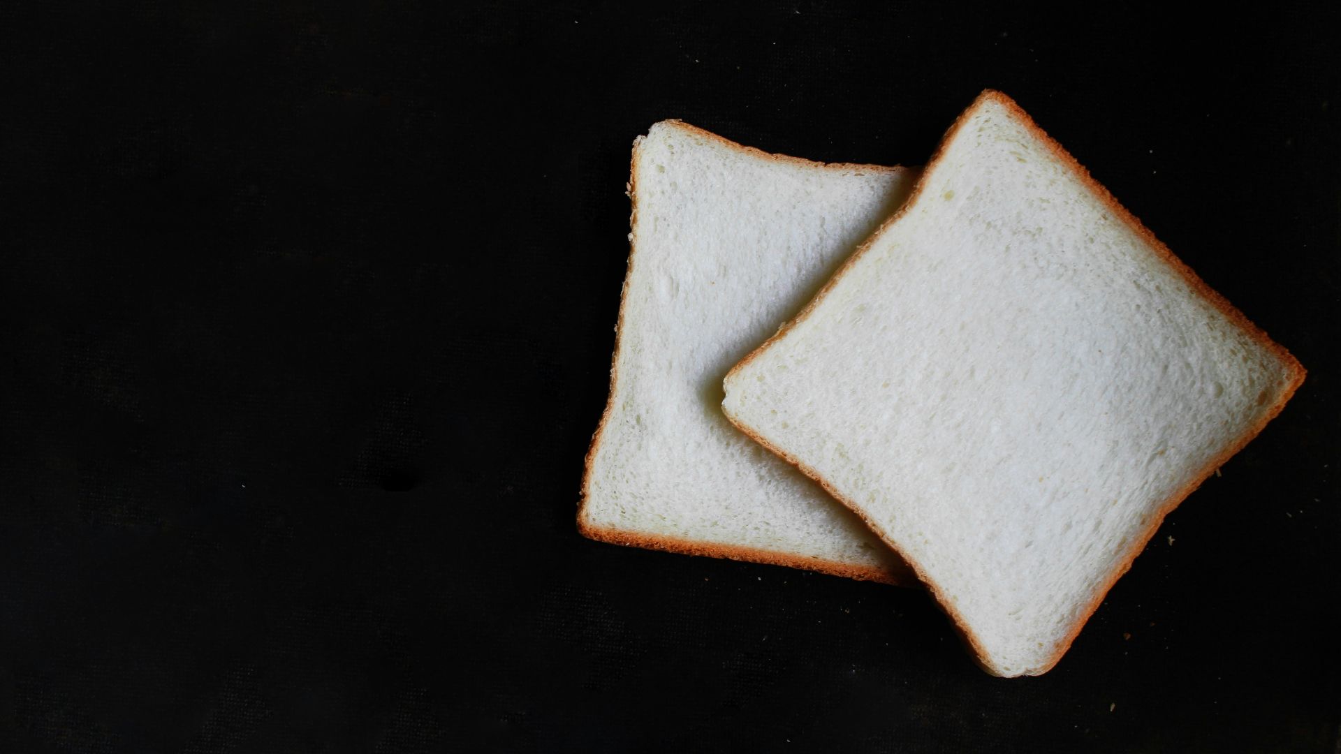 two slices of breads on top of black surface
