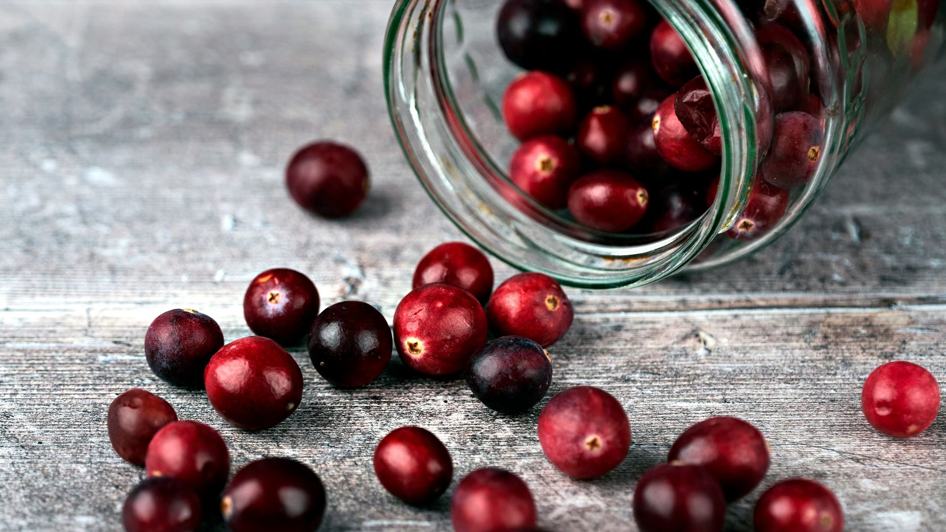 red round fruits in clear glass jar