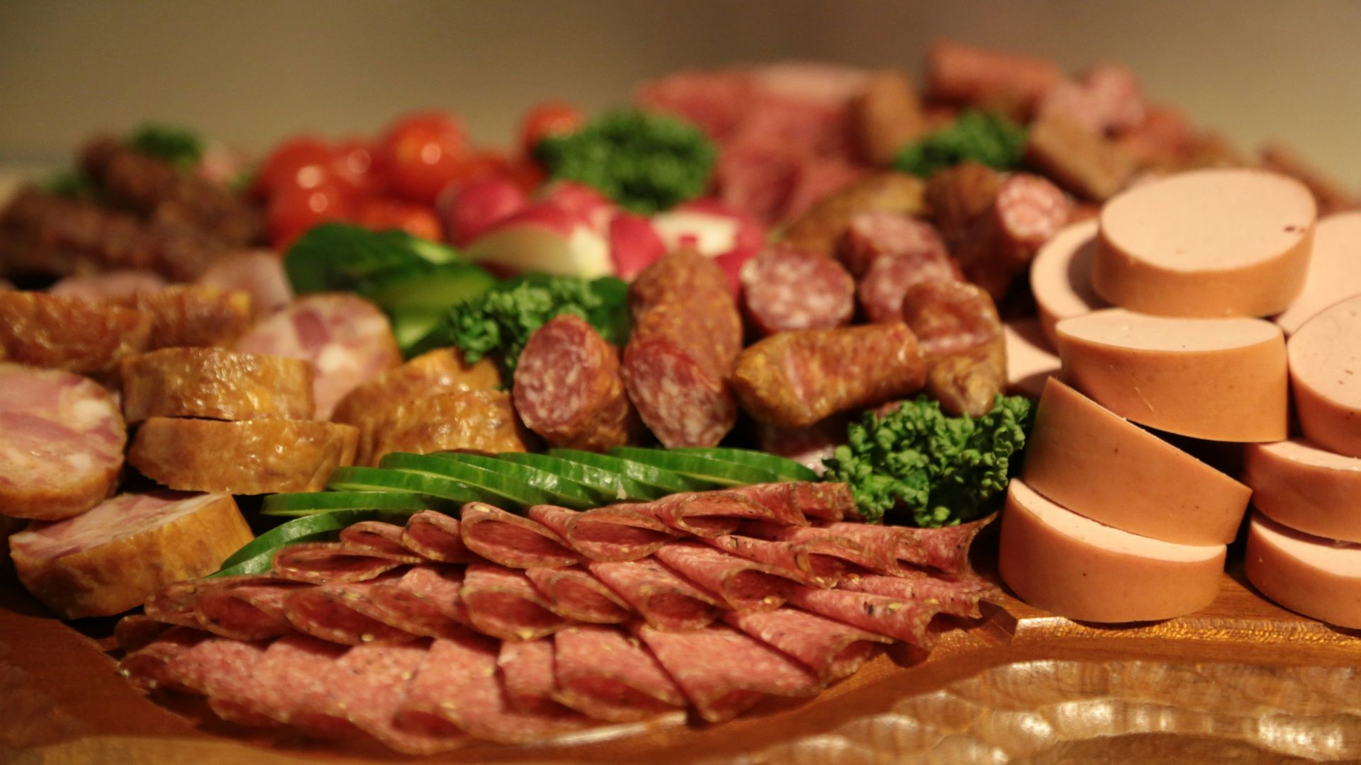 sliced meat with green vegetable on brown wooden round plate