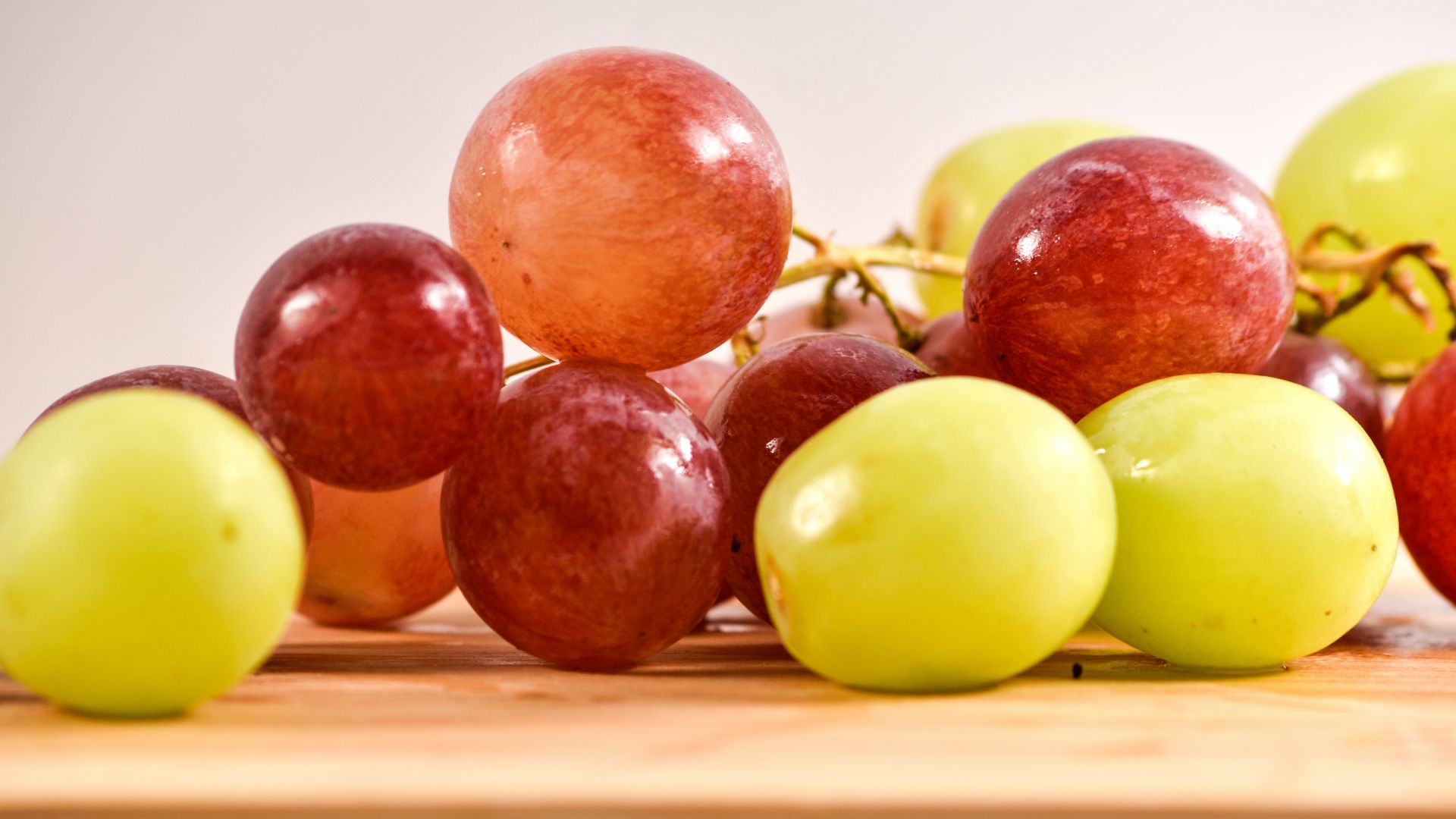 a bunch of grapes sitting on top of a wooden table