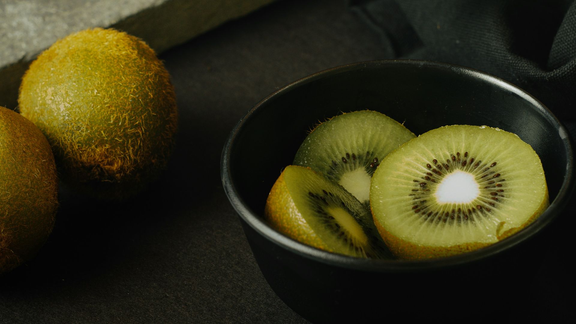 yellow round fruit on black ceramic bowl