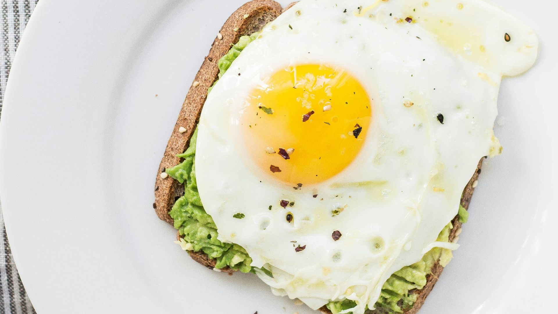 sunny side up egg, lettuce, bread on white ceramic plate