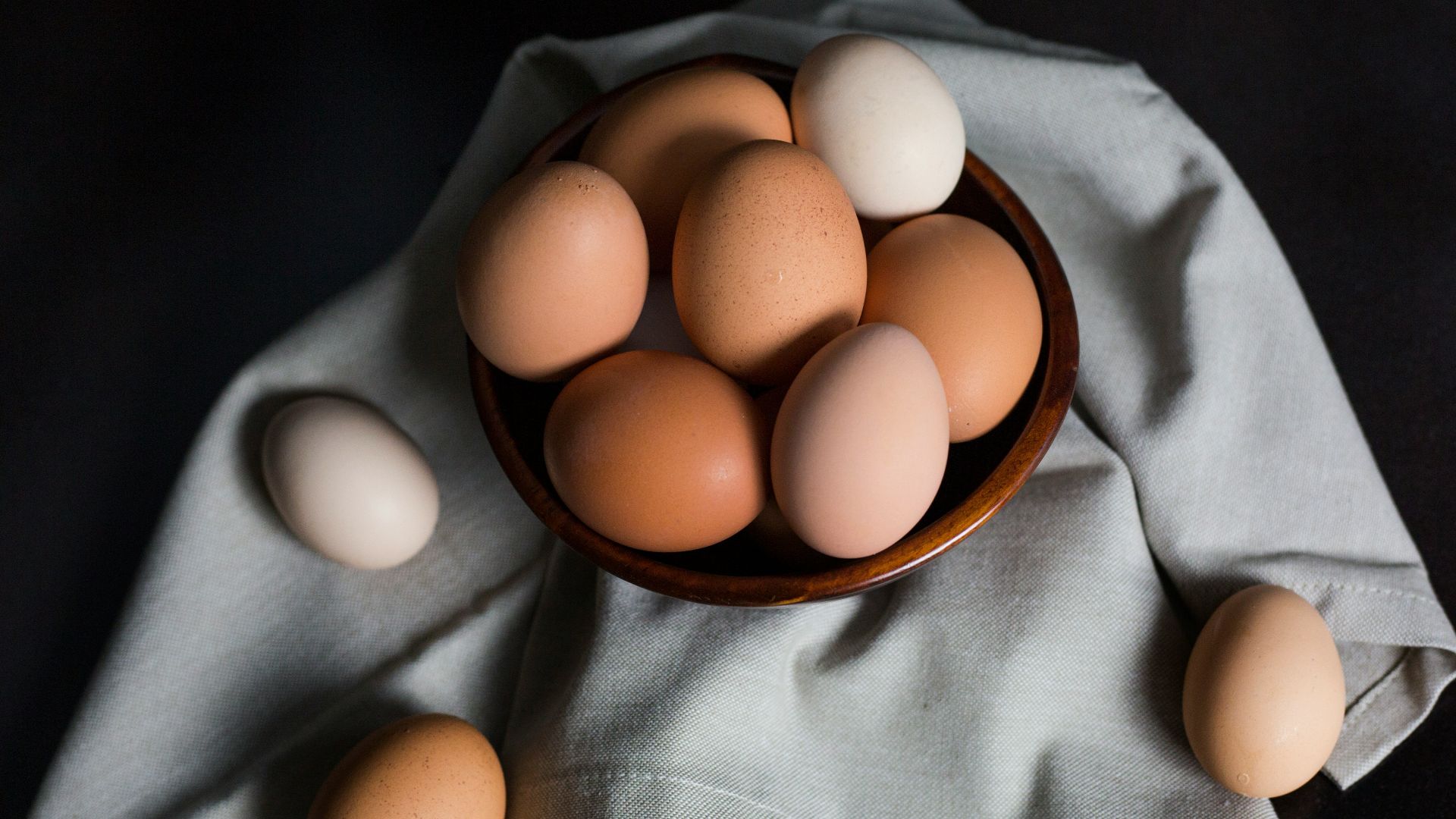 beige and white eggs on brown wooden bowl
