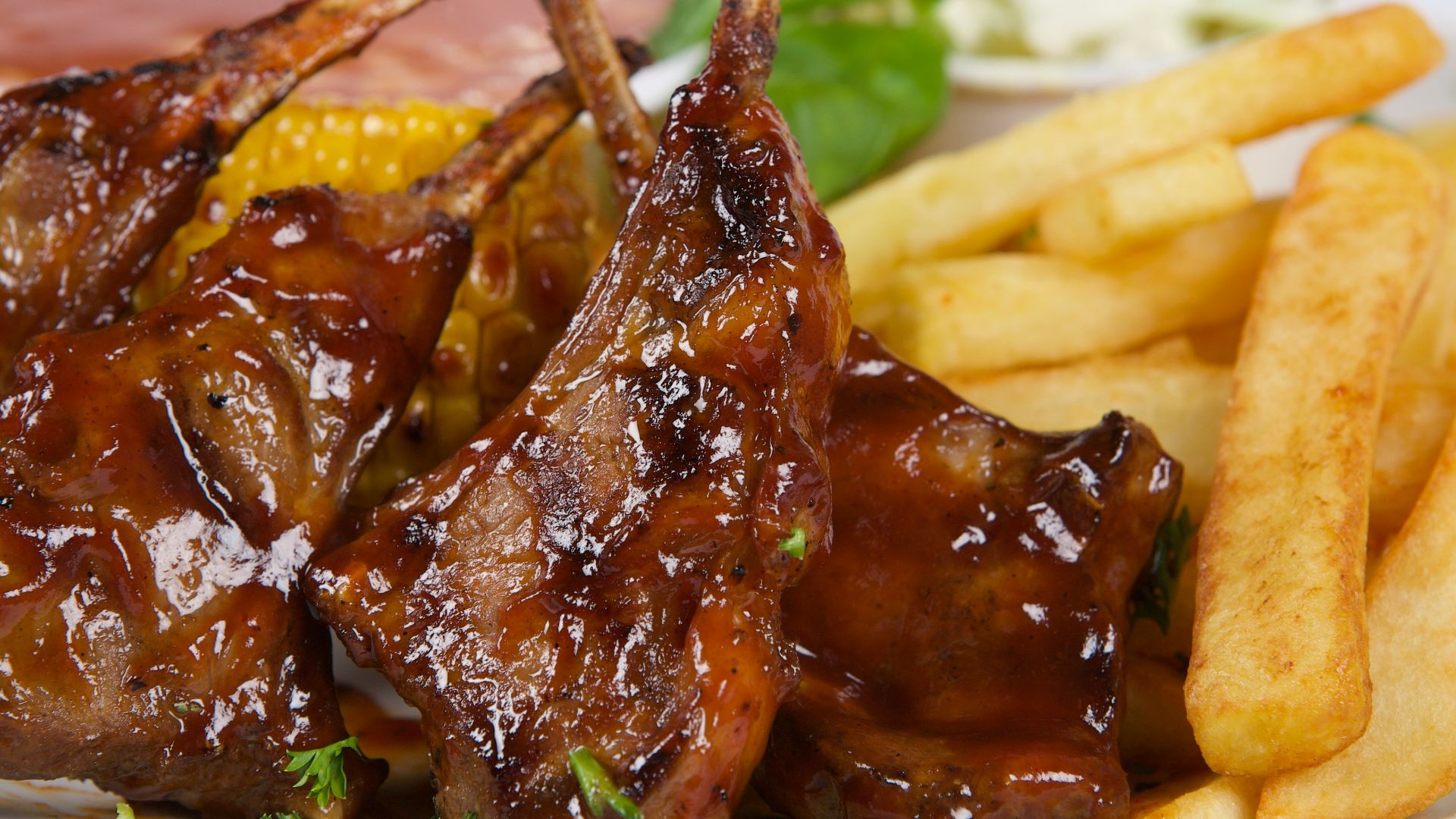 A white plate topped with meat and french fries