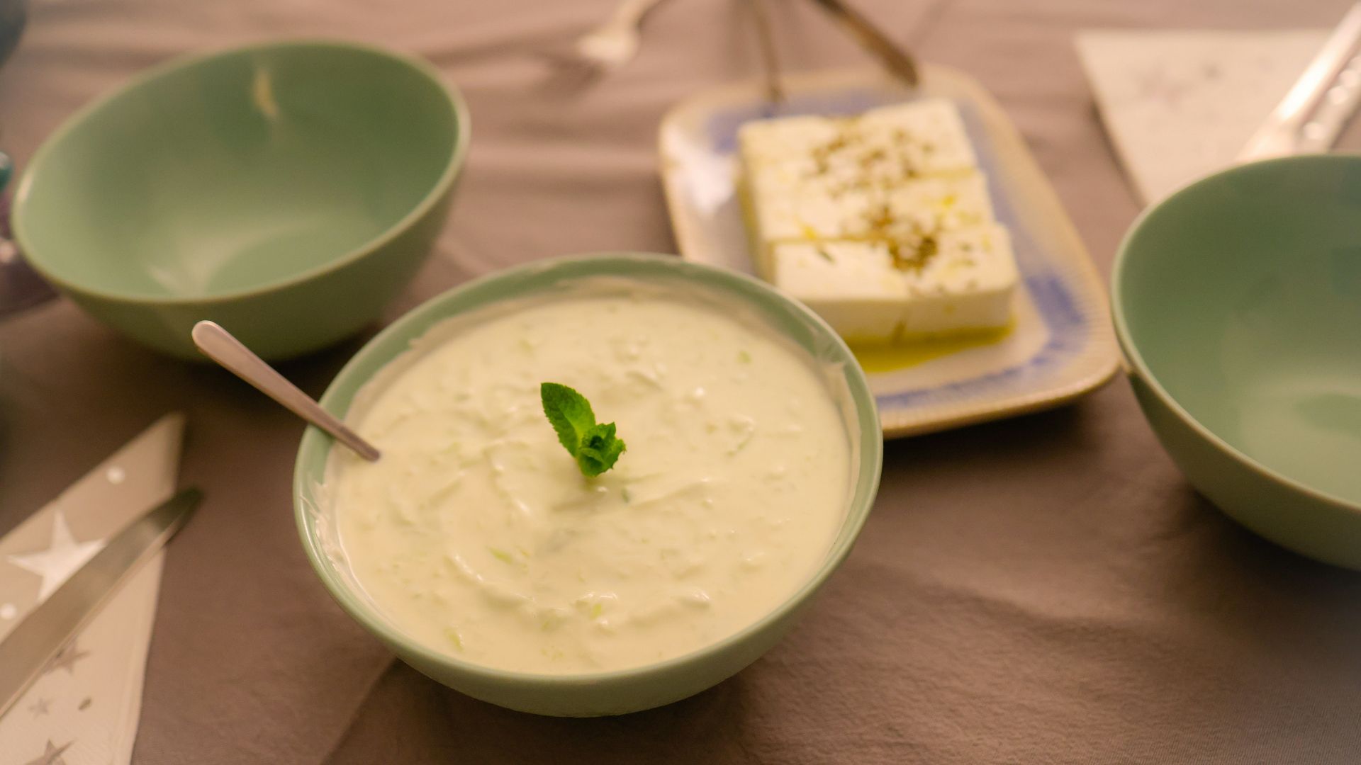 a table topped with bowls of food and a plate of cake