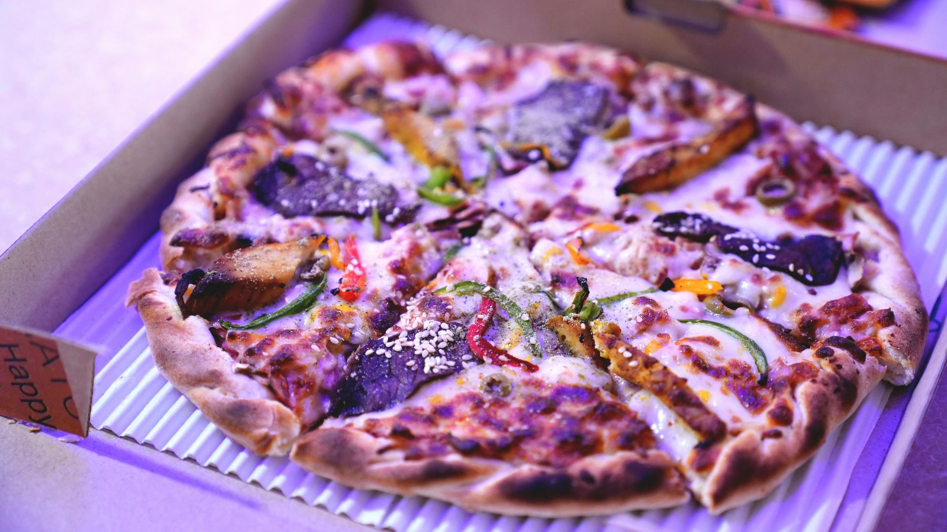 a pizza sitting in a box on top of a table