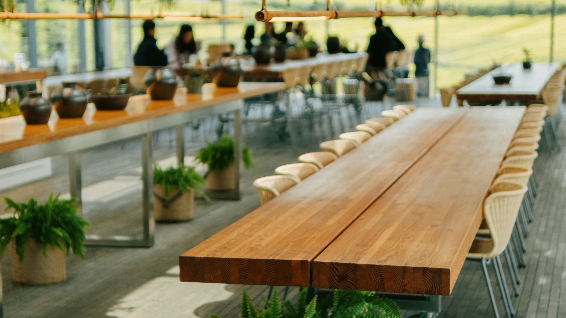 a long wooden table sitting inside of a building