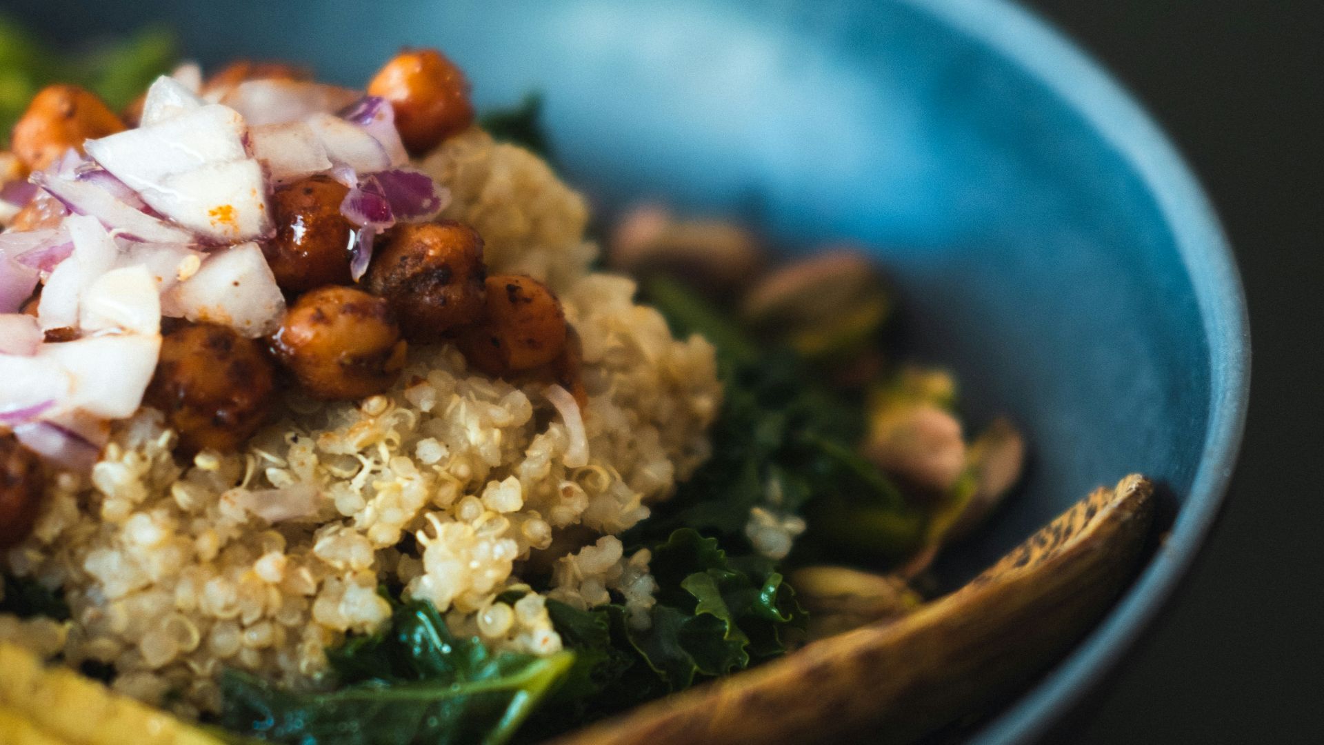 a blue bowl filled with rice and vegetables