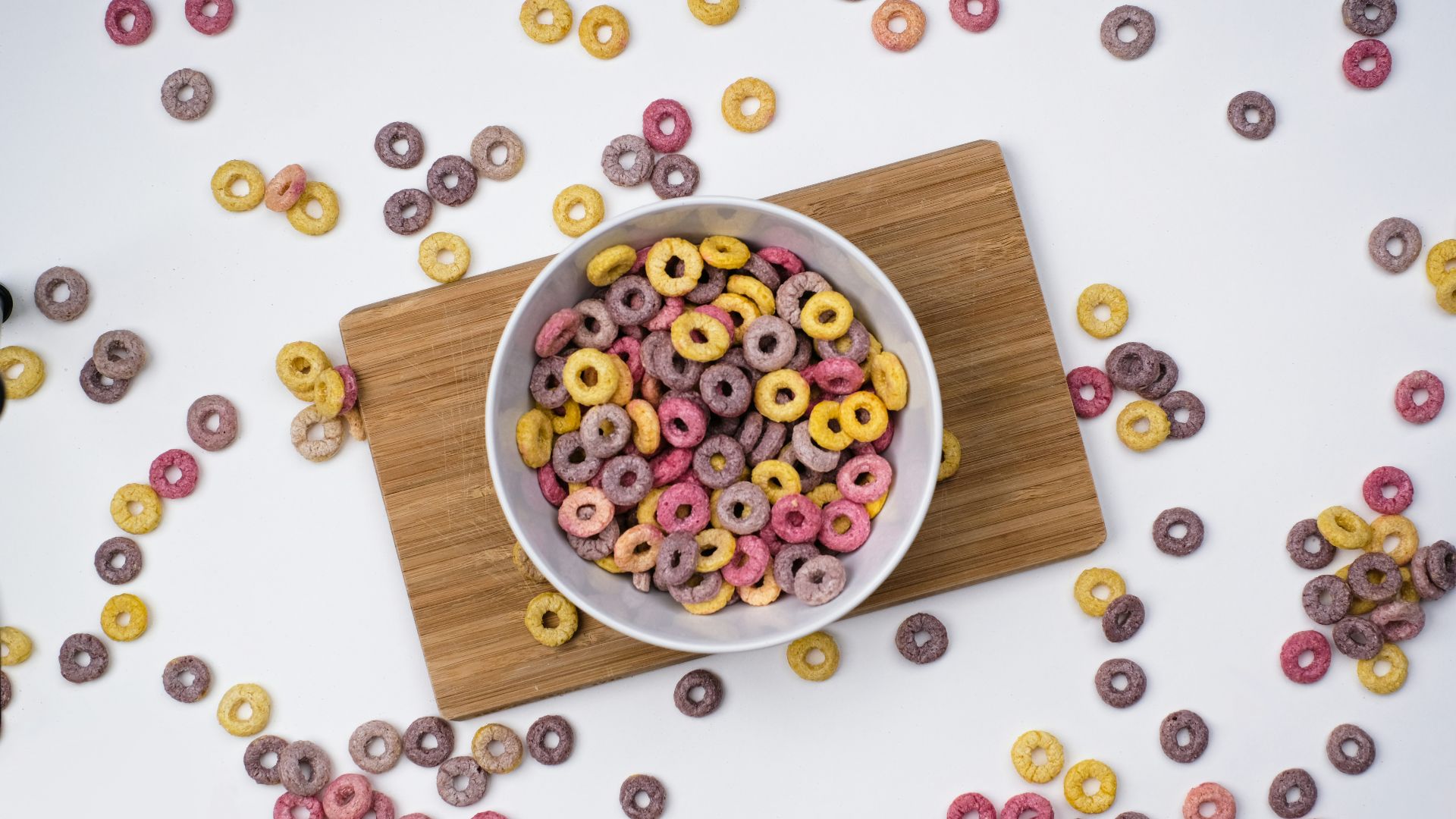 red and blue berries on white ceramic bowl on brown wooden chopping board